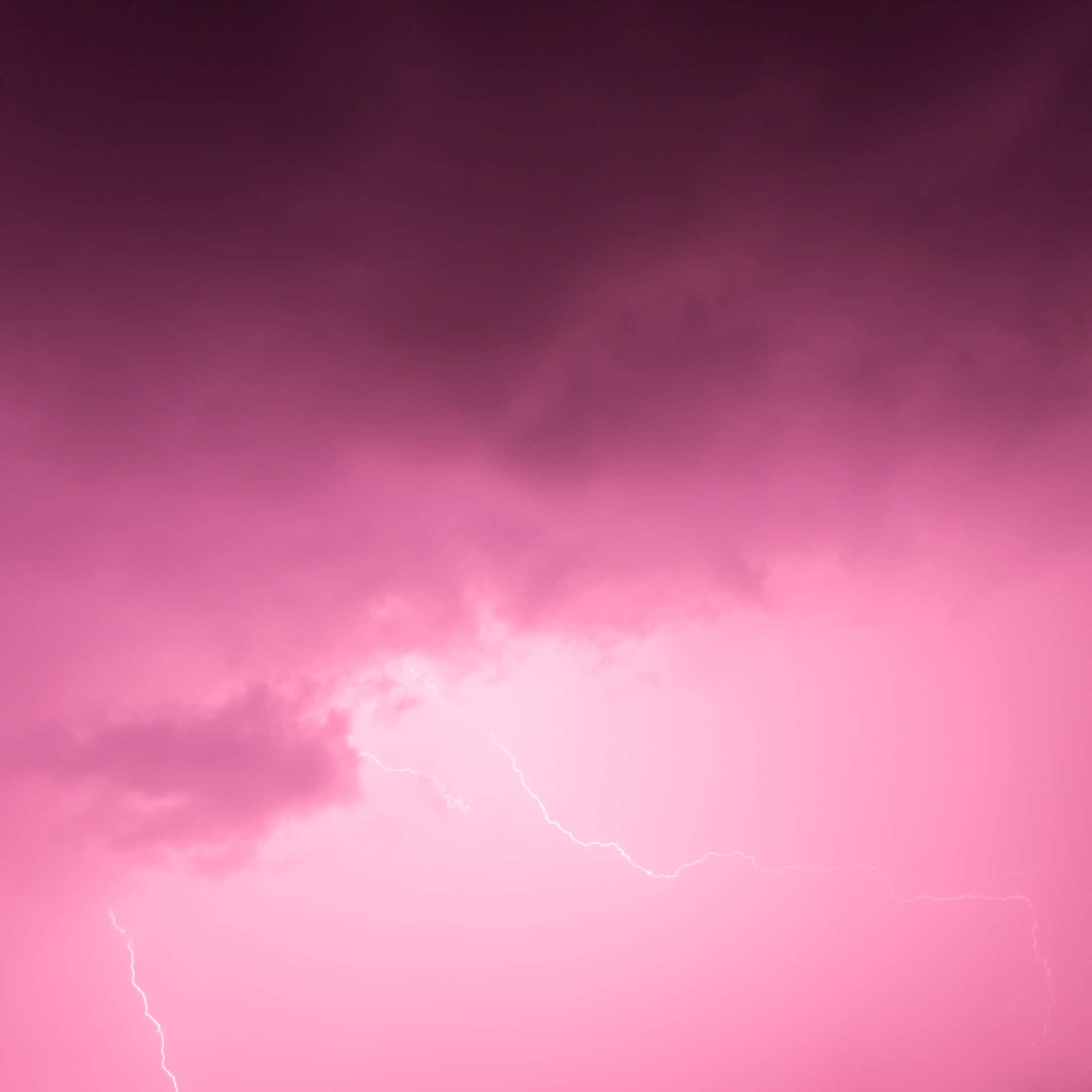帶有明亮閃電的粉紅和紫色暴風雨雲。