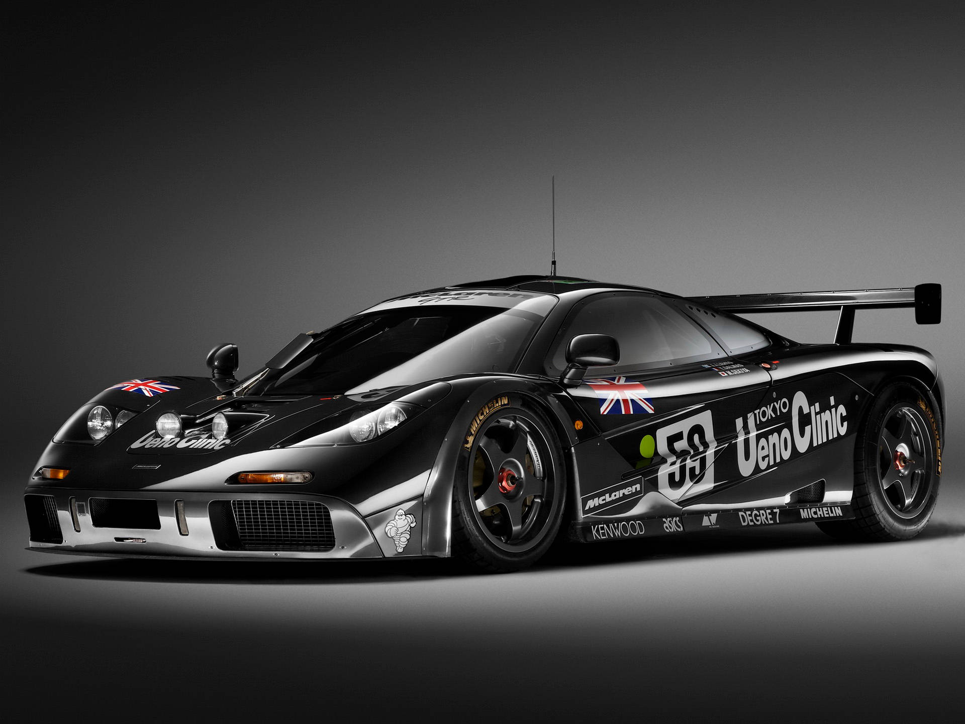 黑色McLaren F1 GTR賽車，帶有英國國旗和贊助商貼紙，在工作室中。