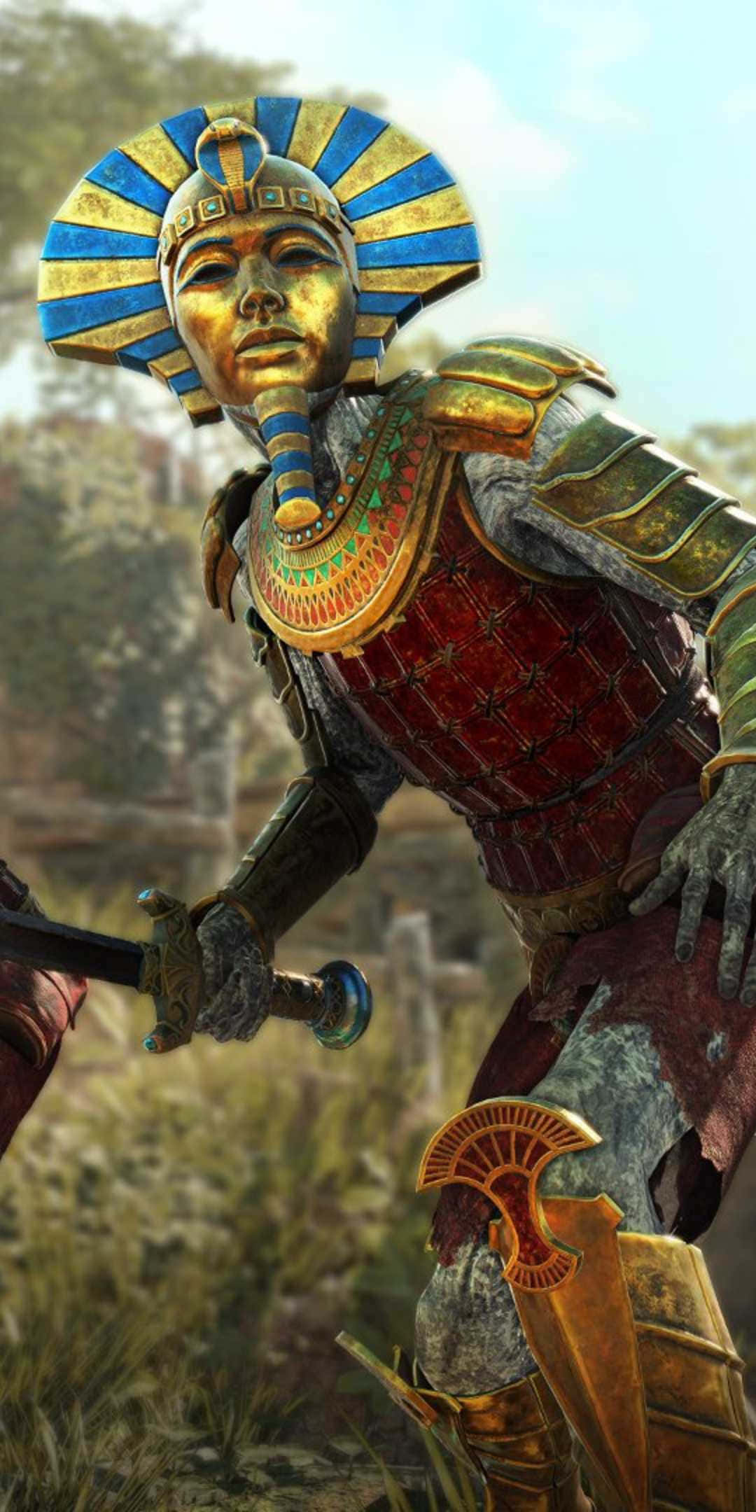 解鎖 Strange Brigade 的秘密 壁紙 — 一名身穿華麗金色埃及盔甲、頭戴藍金頭飾的戰士，佇立在陽光照耀的草地上。