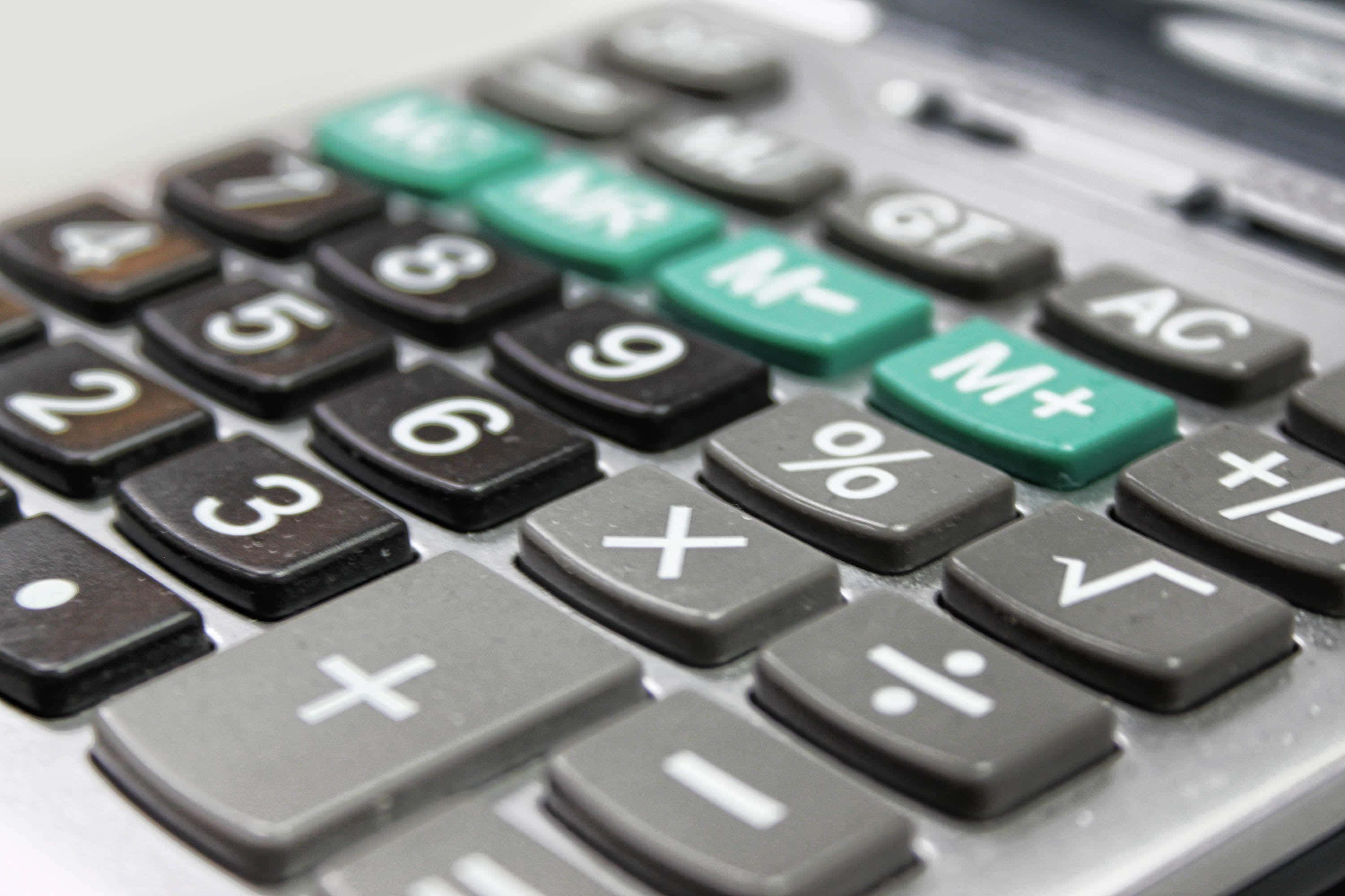 Calculator 桌布 壁紙 — 計算機鍵盤特寫，帶有磨損的黑色和綠色按鈕，顯示數字和數學符號。