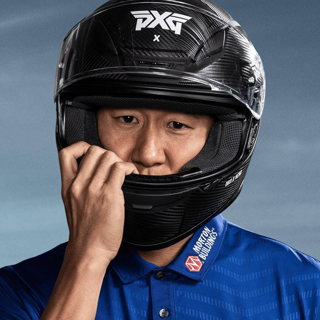高爾夫球手穿著藍色Polo衫調整黑色碳纖維頭盔的面罩。