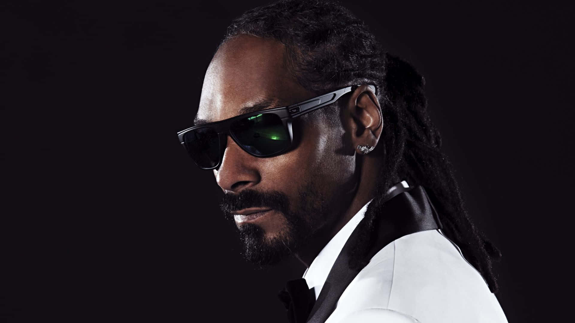 Snoop Dogg 身穿白色西裝和黑色太陽眼鏡，表情自信。
