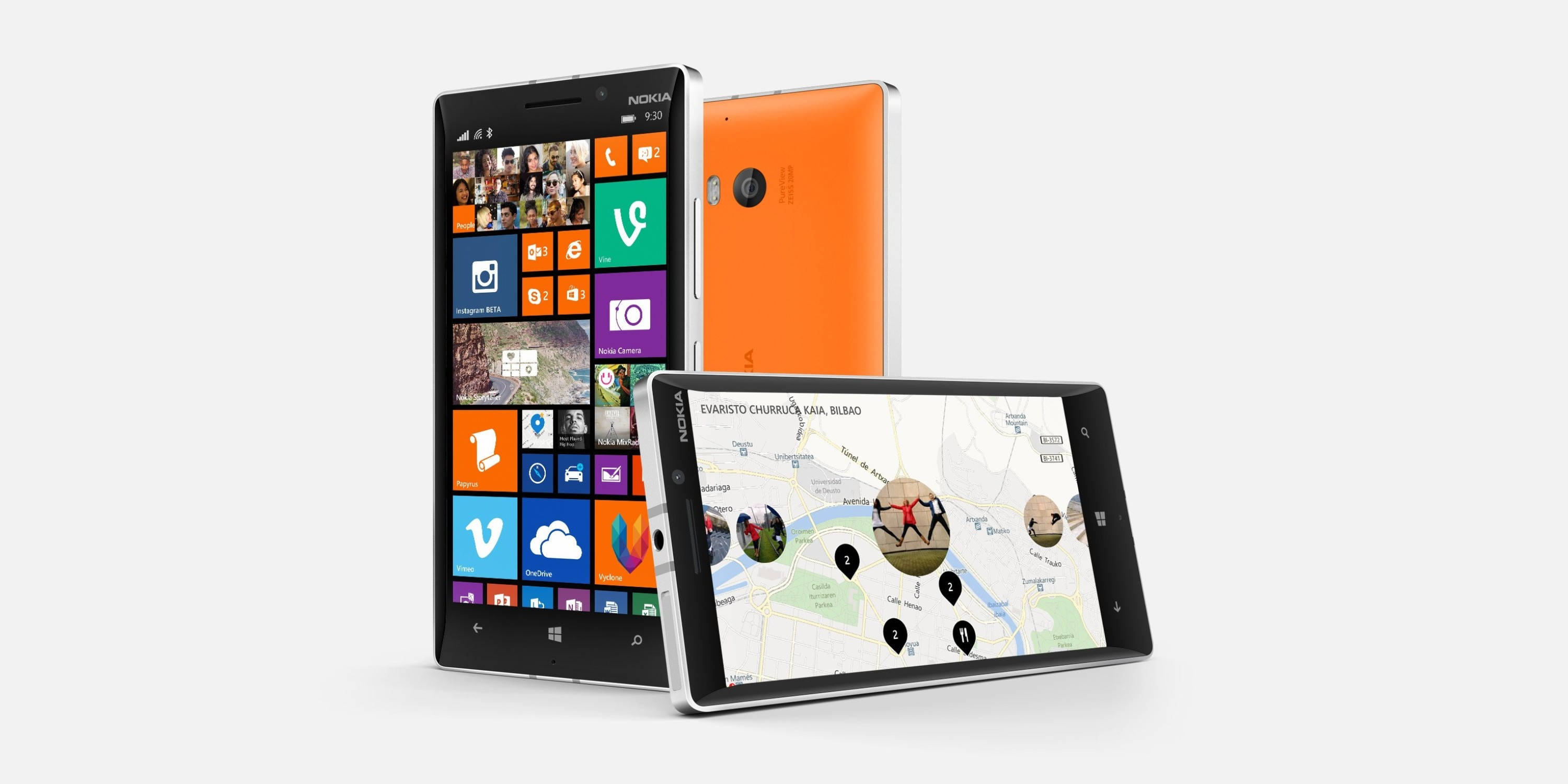 諾基亞 Lumia 930 智能手機 壁紙 — 三部 Nokia Lumia 智能手機以不同角度展示，呈現色彩繽紛的 Windows Phone 介面和地圖應用程式，背景為純白色。