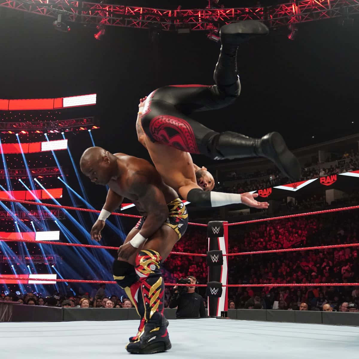摔角手在WWE RAW活動中，在充滿活力的舞台燈光下進行動作。