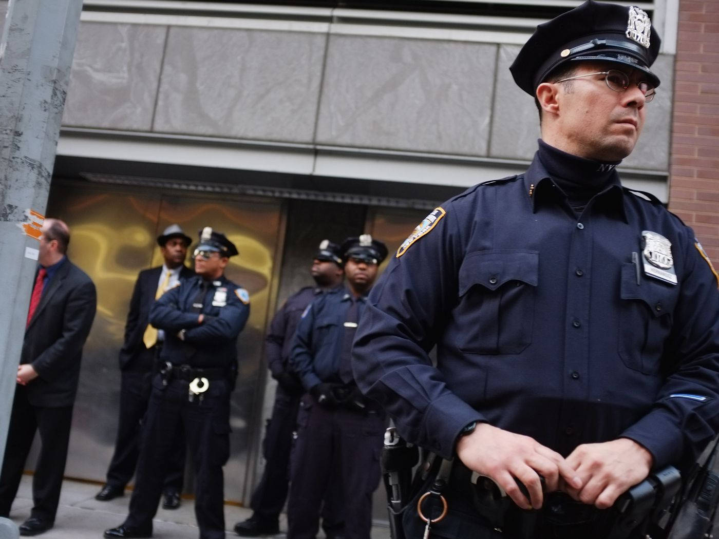 警察在建築物附近的城市人行道上站崗。