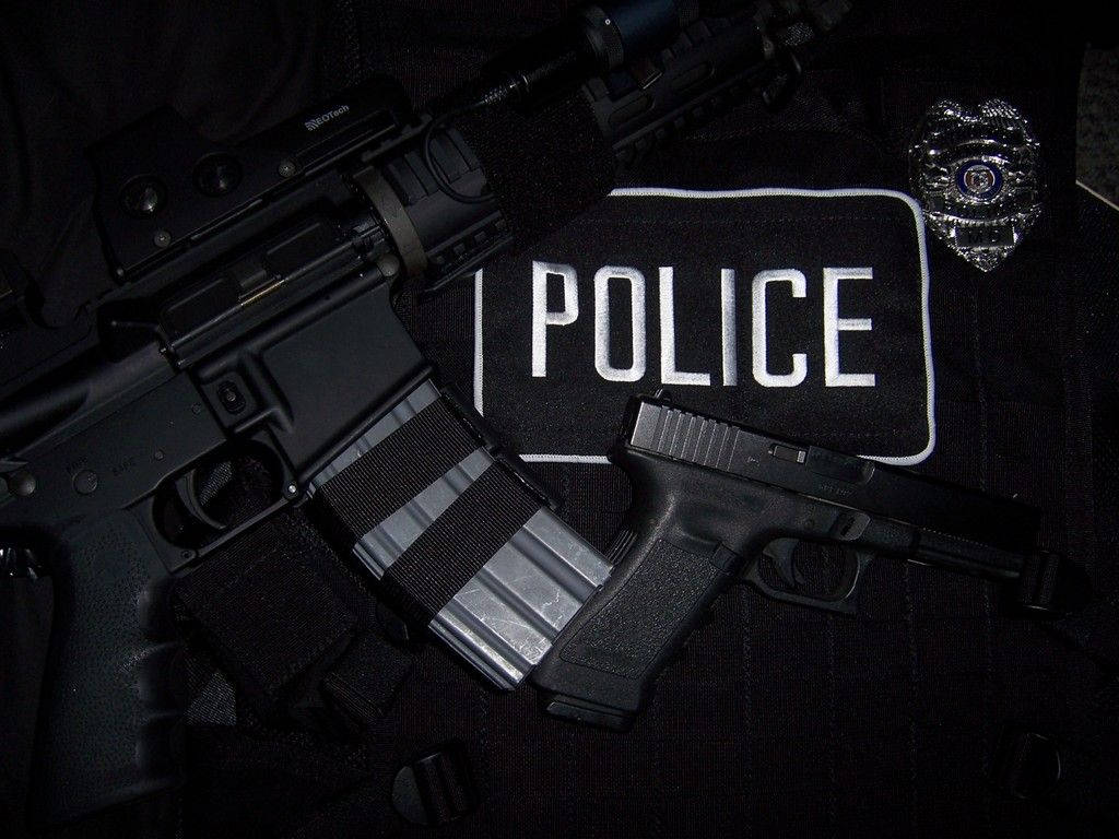 警察步槍手槍和徽章放在帶有警察補丁的制服上。