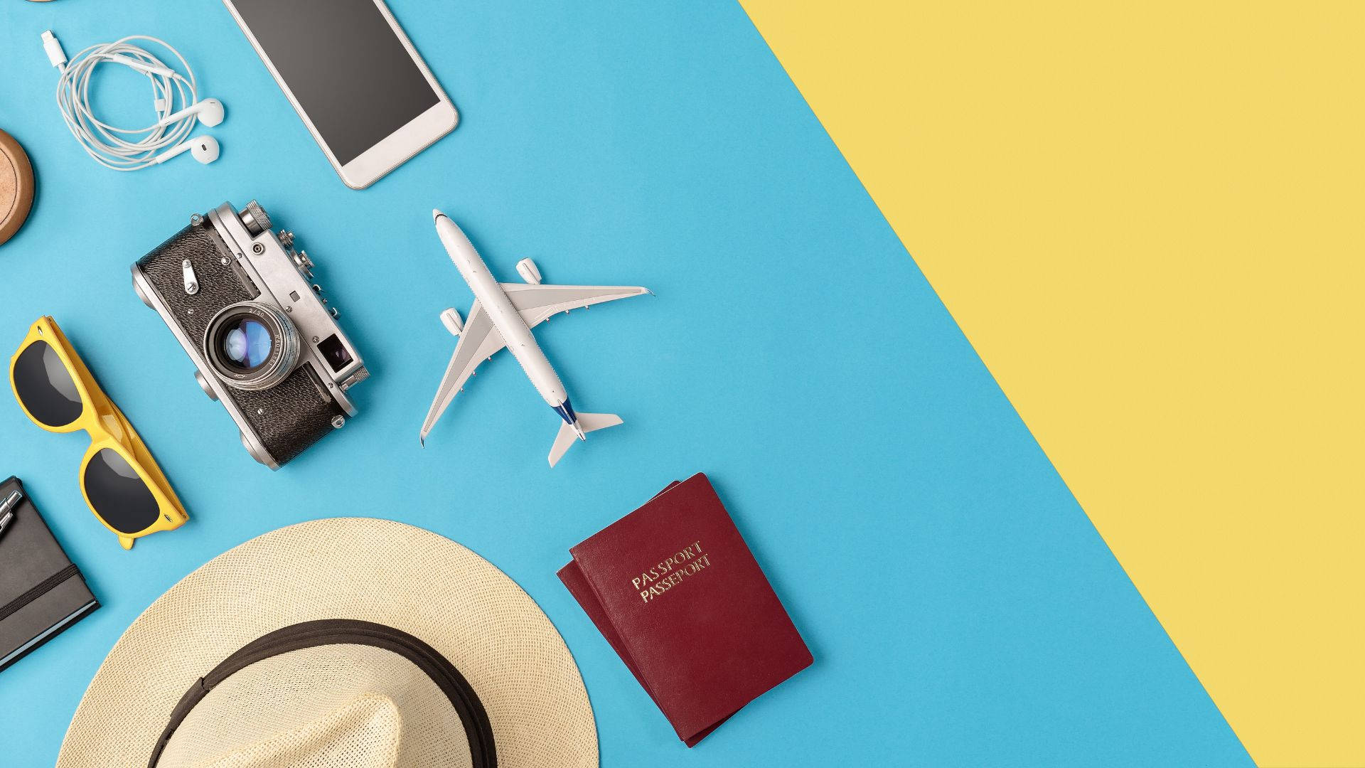 護照與各類旅行用品 壁紙 — 旅行裝備的平面佈置，包括護照、太陽眼鏡、相機和飛機模型，在鮮明的藍色和黃色背景上。