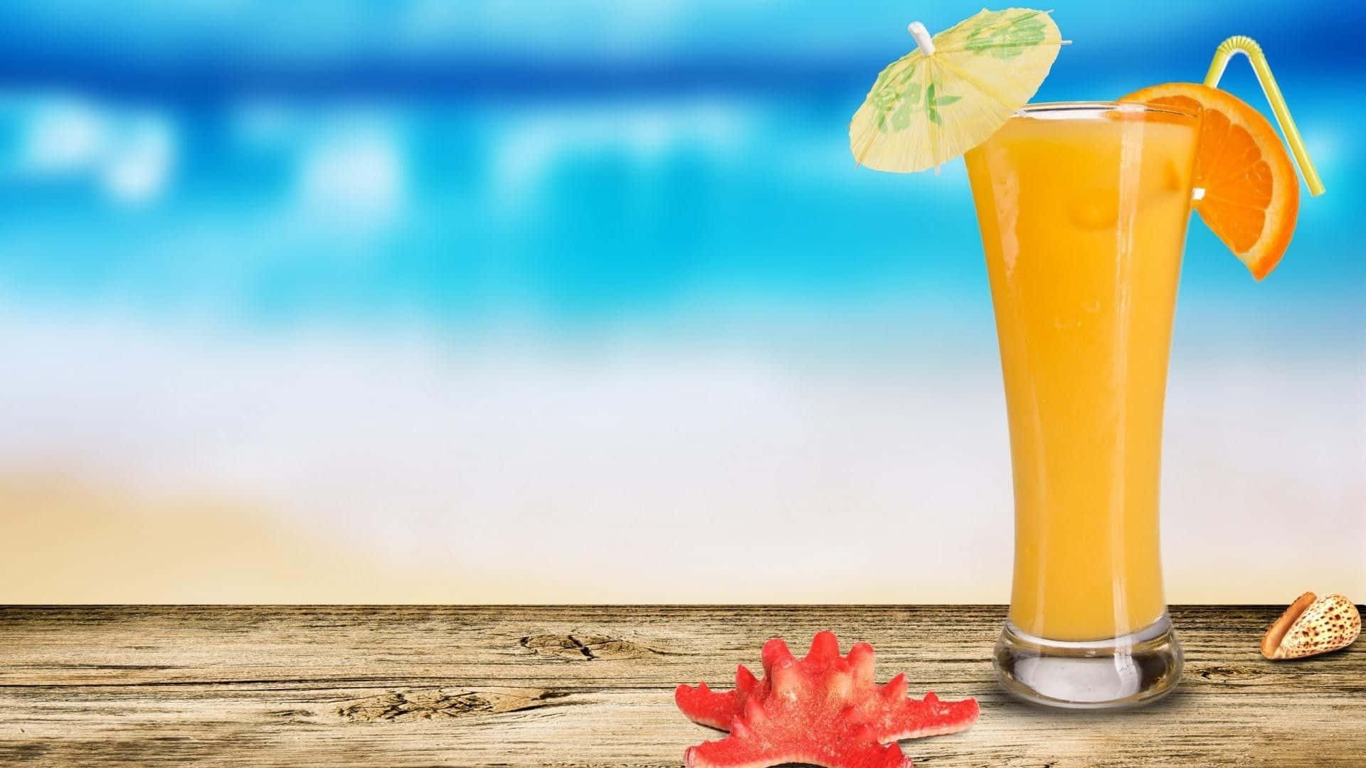 讓你的夏天精彩絕倫 壁紙 — 一杯高身橙色熱帶飲品，附有傘子和橙片，放在經風化的木頭上，背景是模糊的海灘。