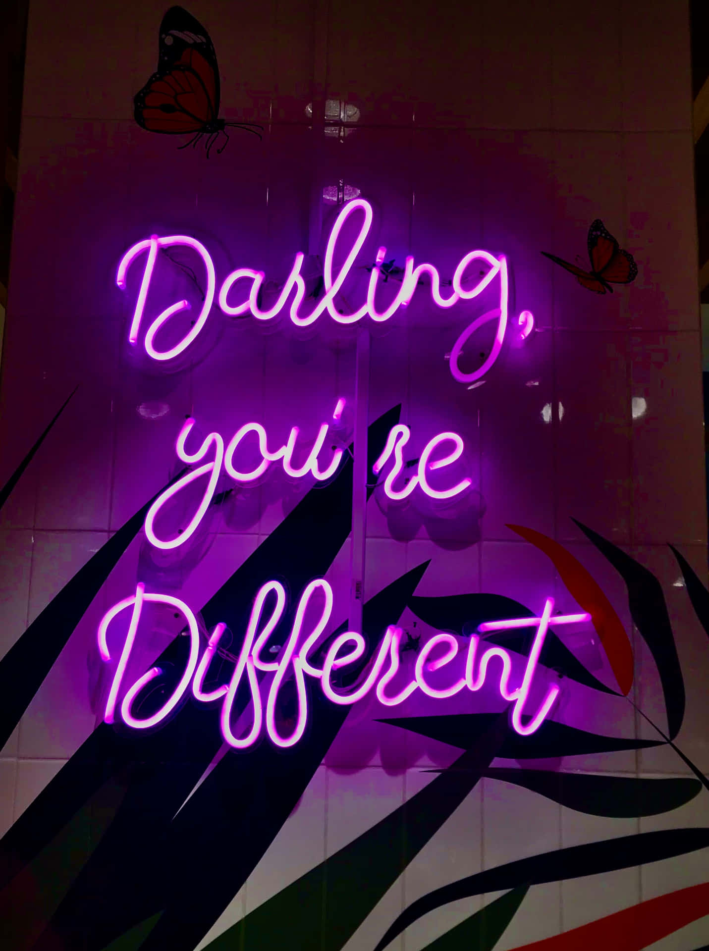 紫色霓虹燈牌寫著 Darling you're Different，瓷磚牆上有蝴蝶貼紙。