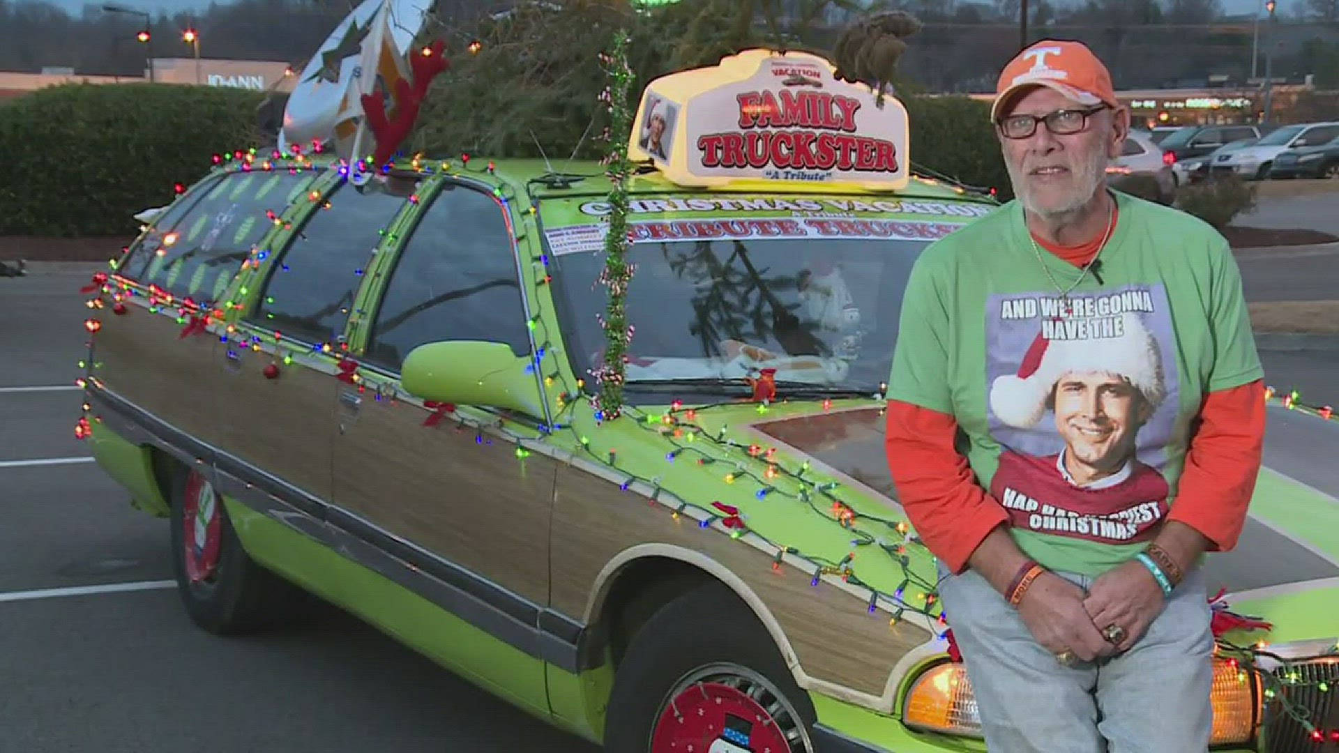 男子與一輛以 Family Truckster 為主題的聖誕裝飾旅行車合影。
