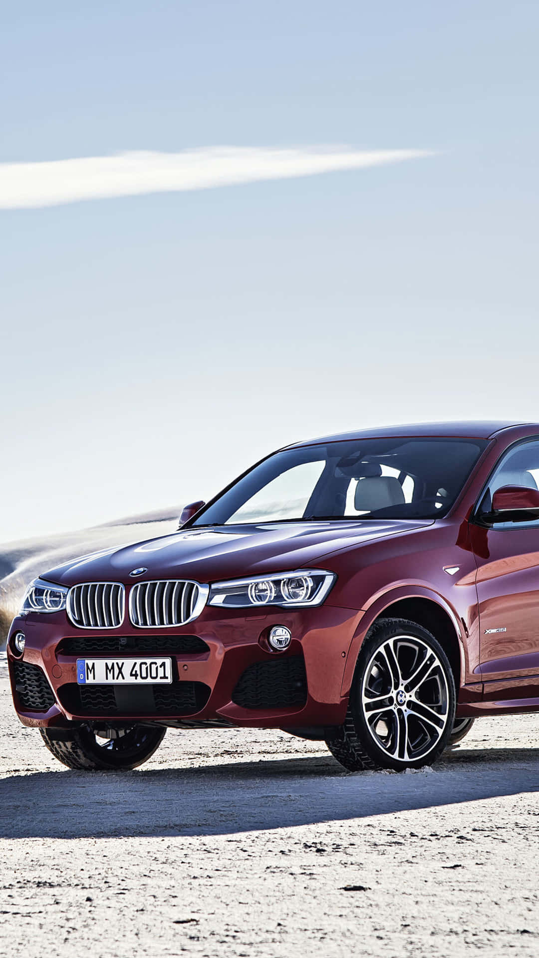 紅色BMW X4 SUV停泊在沙漠公路，夕陽西下