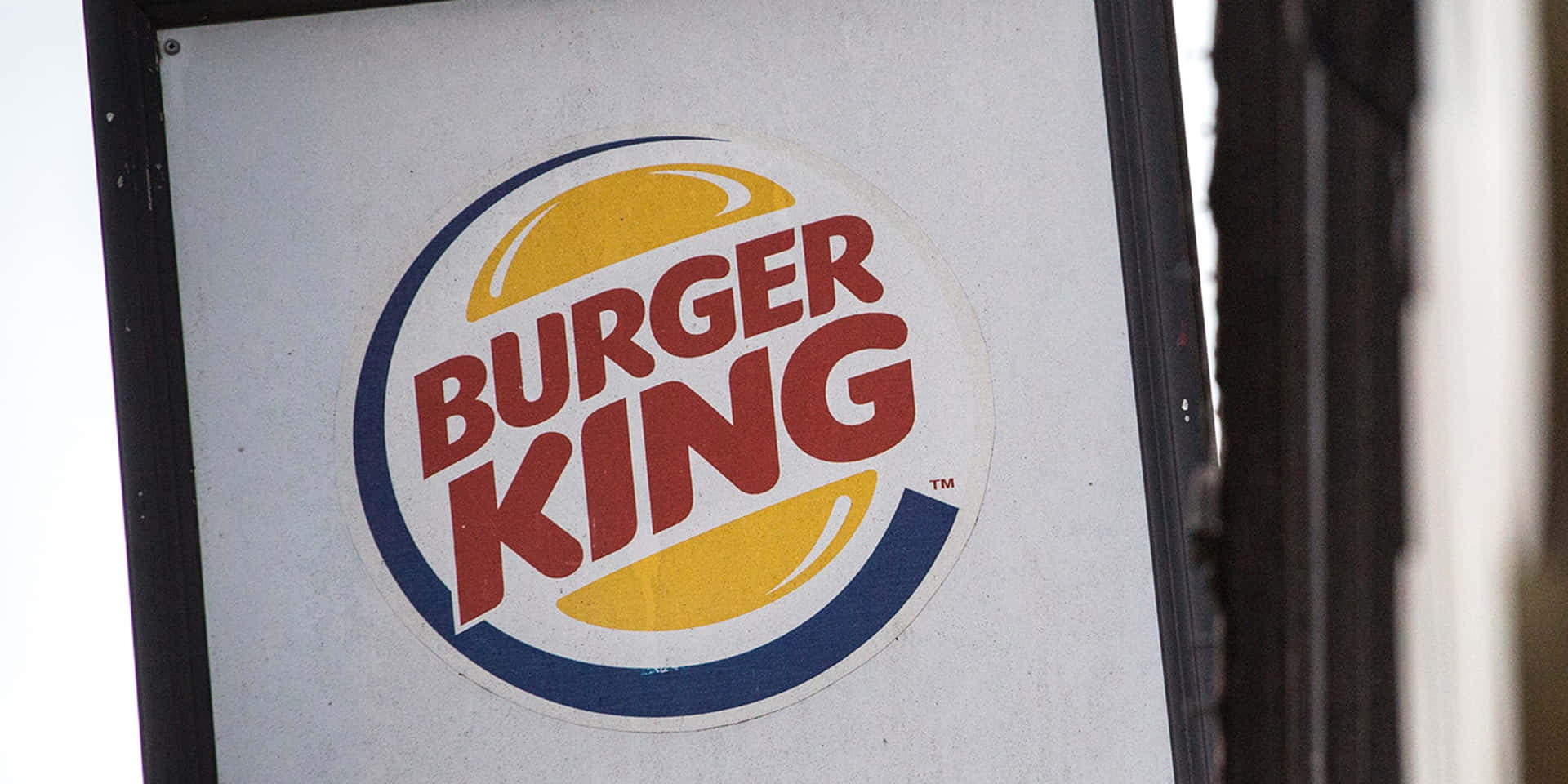 帶有紅色、黃色和藍色標誌嘅Burger King餐廳招牌