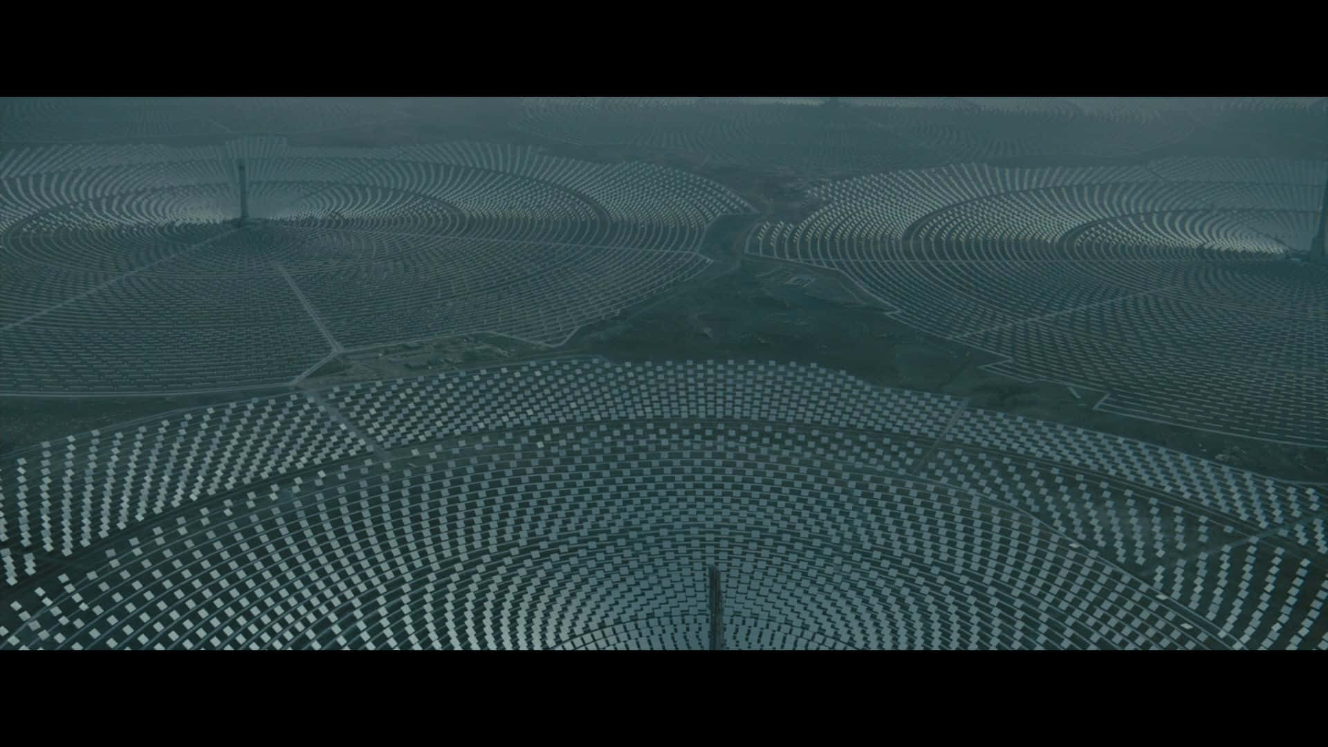 從高空俯瞰，霧氣瀰漫的景觀中的彎曲太陽能農場。
