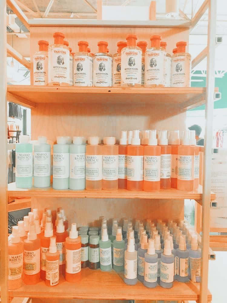 木架上擺滿了粉彩和橙色調的 Mario Badescu 和 Thayers 護膚產品。
