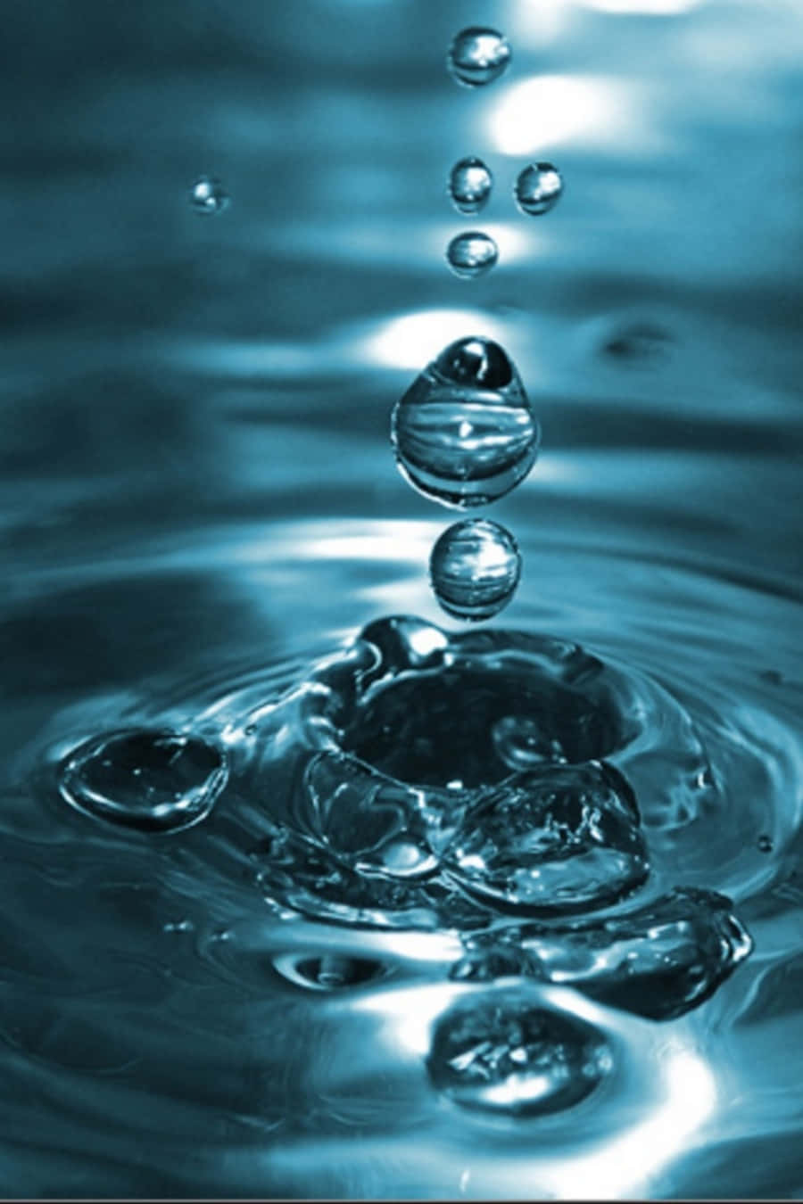水滴懸浮在泛起漣漪的水面上，呈現清涼的藍色調。