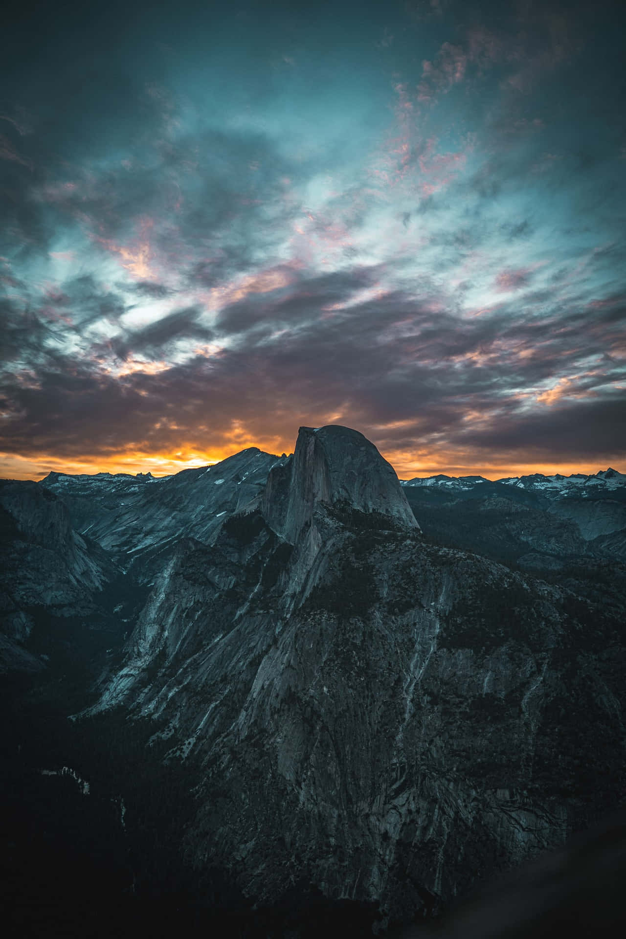 暮色中的半圓頂山，上方有彩色雲朵