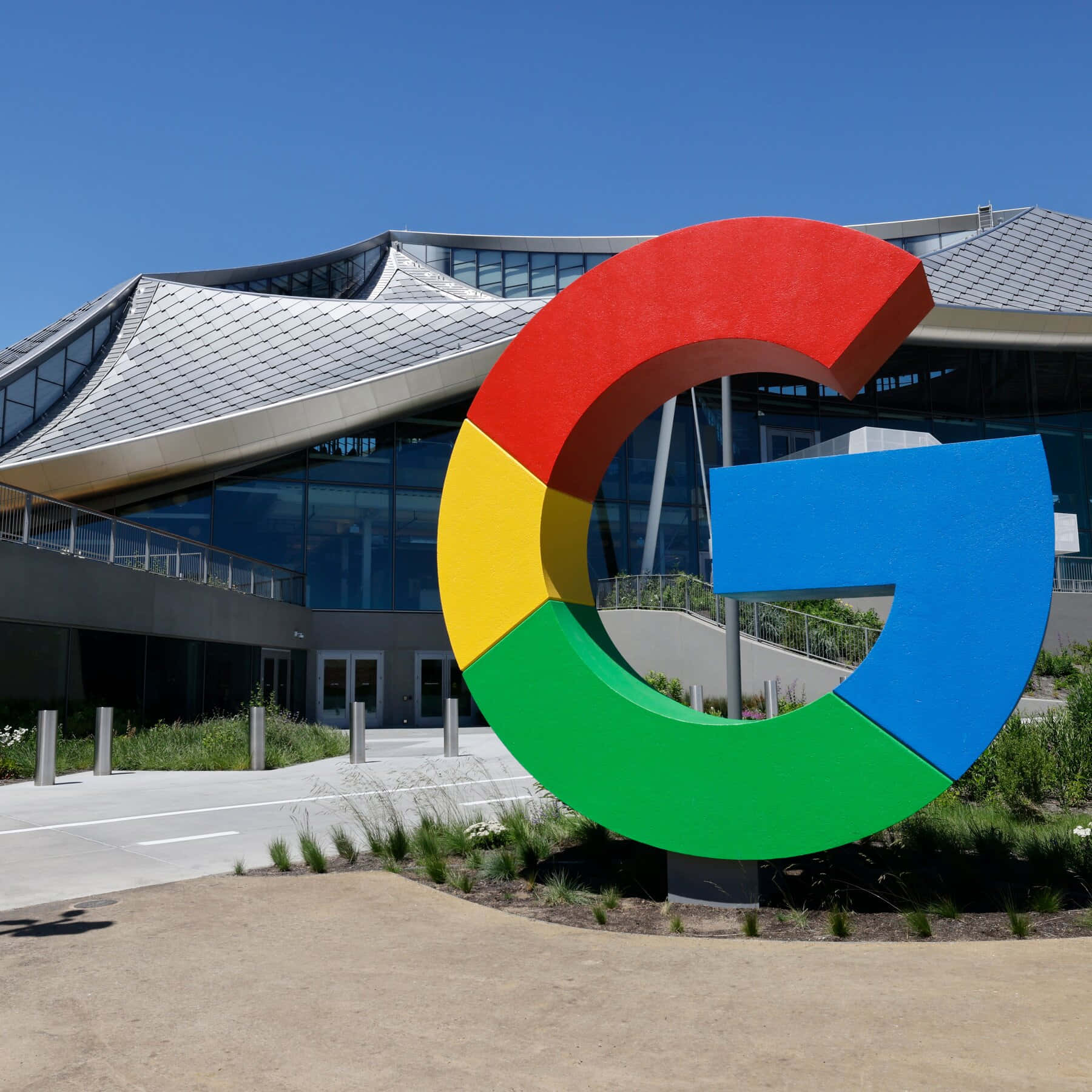 陽光明媚的日子裡，現代辦公樓前的大型Google G標誌雕塑。