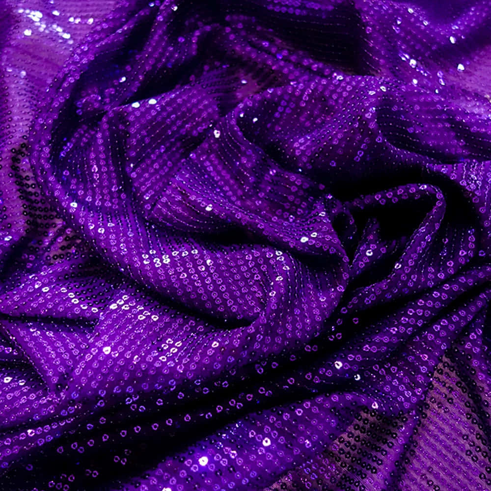 Purple Sequins 桌布 壁紙 — 豐富的紫色布料，閃爍的亮片在深褶中捕捉光線，營造出奢華閃爍的質感。