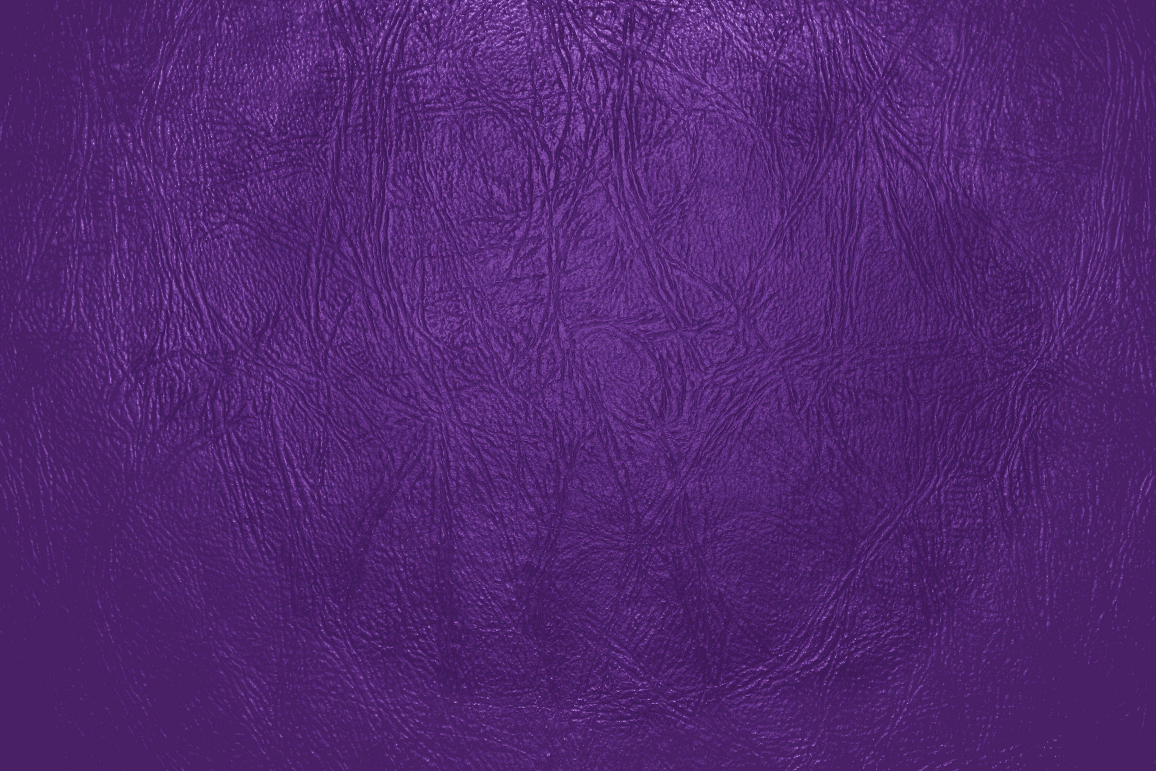 Purple Leather 桌布 壁紙 — 豐富的紫色皮革紋理，在柔和光線下帶有細微皺褶和天然粒面圖案。
