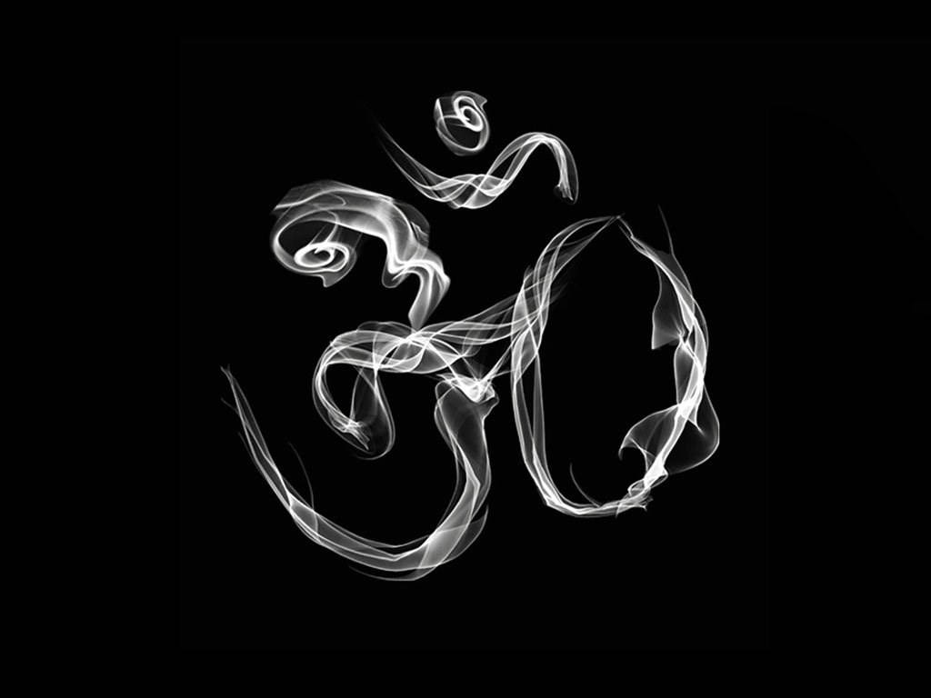 白色煙霧在黑色背景上形成 Om 符號。