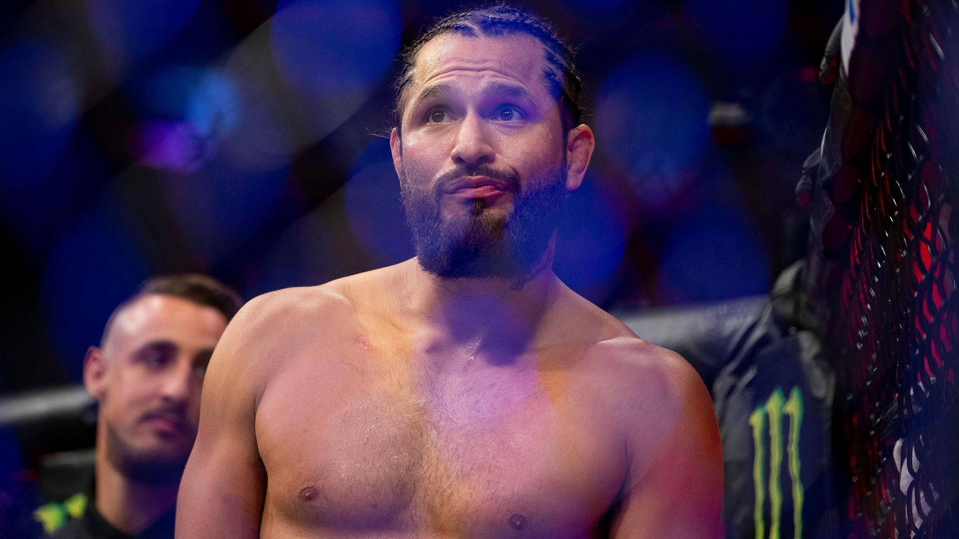 在場館燈光下，八角籠中專注的MMA拳手。