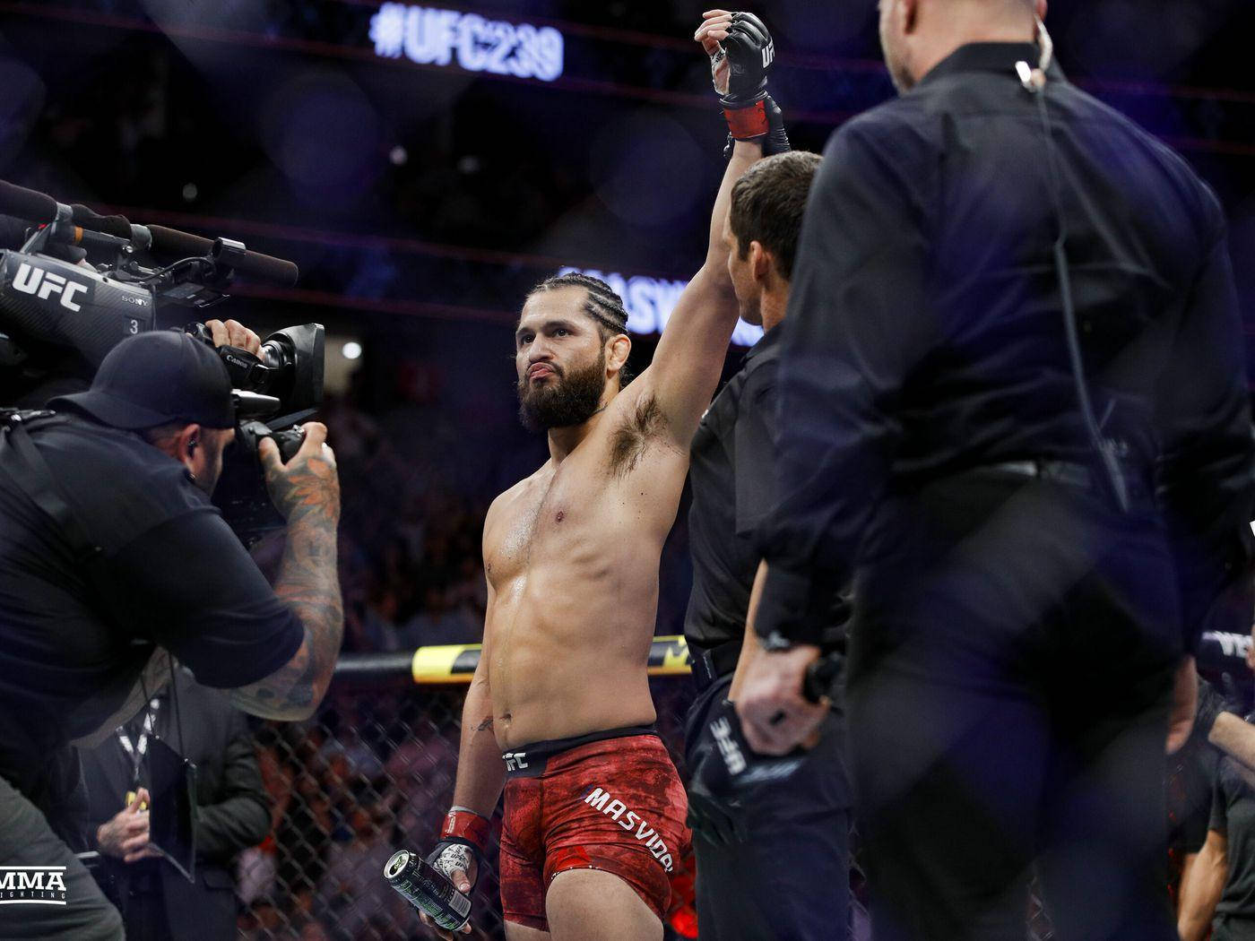 UFC拳手在八角籠內舉拳慶祝勝利。