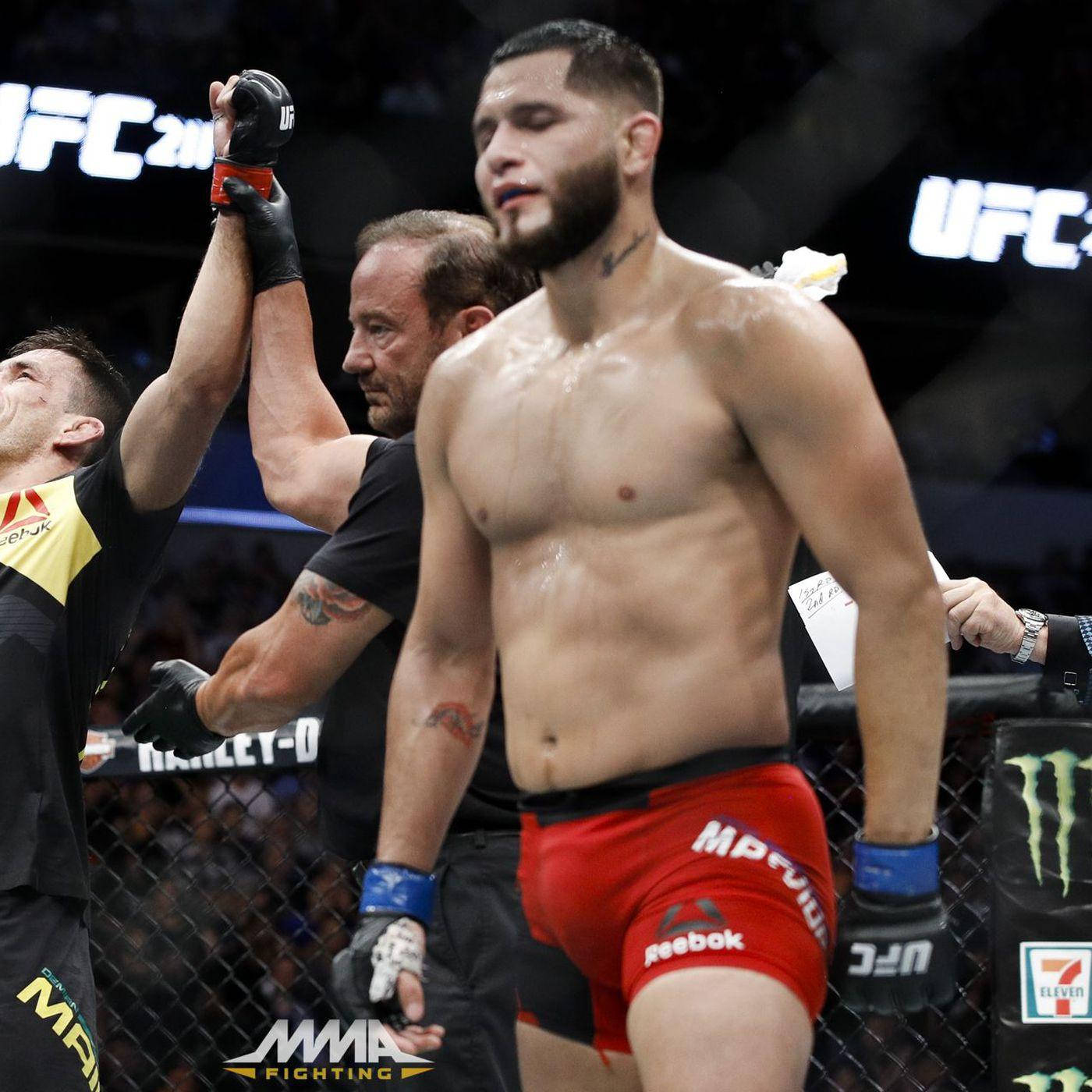 UFC拳手在八角籠中慶祝勝利，裁判舉起他的手。