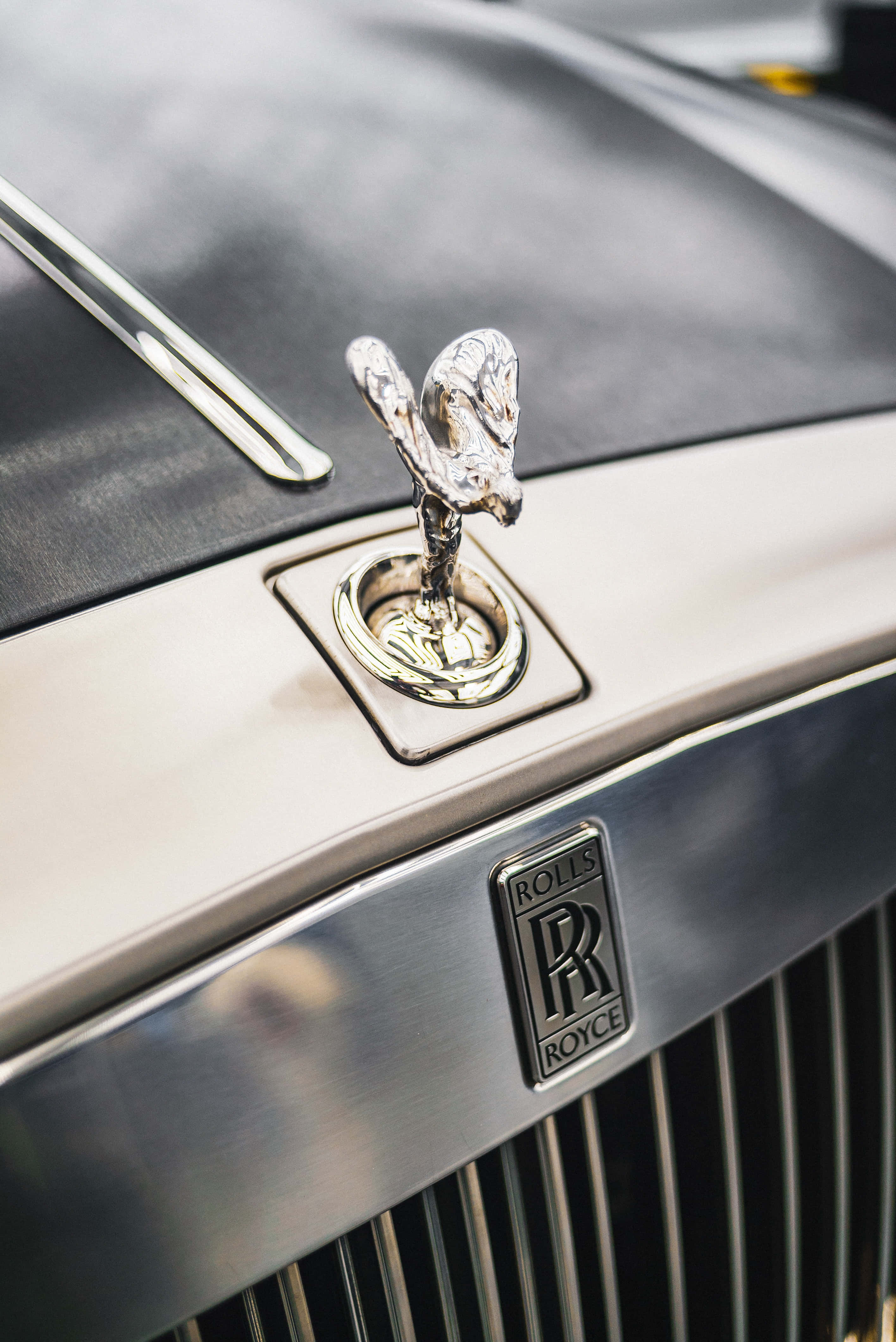 Rolls Royce 桌布 壁紙 — 豪華房車上閃閃發光的銀色勞斯萊斯引擎蓋飾物和格柵的特寫。