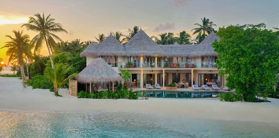 Maldives Island 桌布 壁紙 — 豪華水上別墅，茅草屋頂，私人泳池，坐落在熱帶海灘上，金色日落時分。