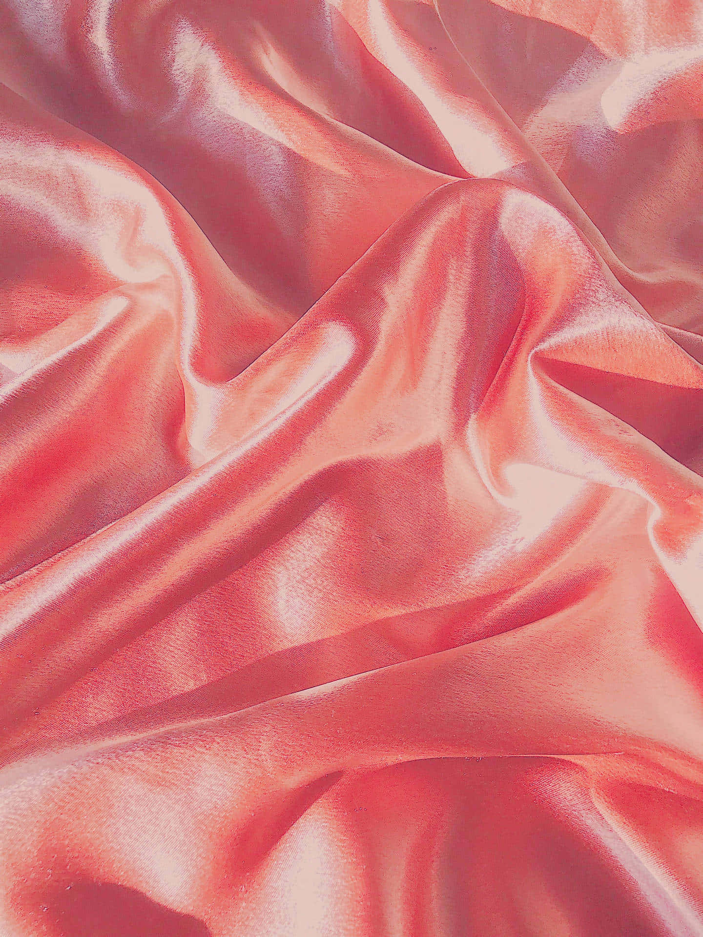 Pastel Red Aesthetic 桌布 壁紙 — 豪華珊瑚色緞面布料，在暖光下呈現柔軟皺褶和閃亮高光。