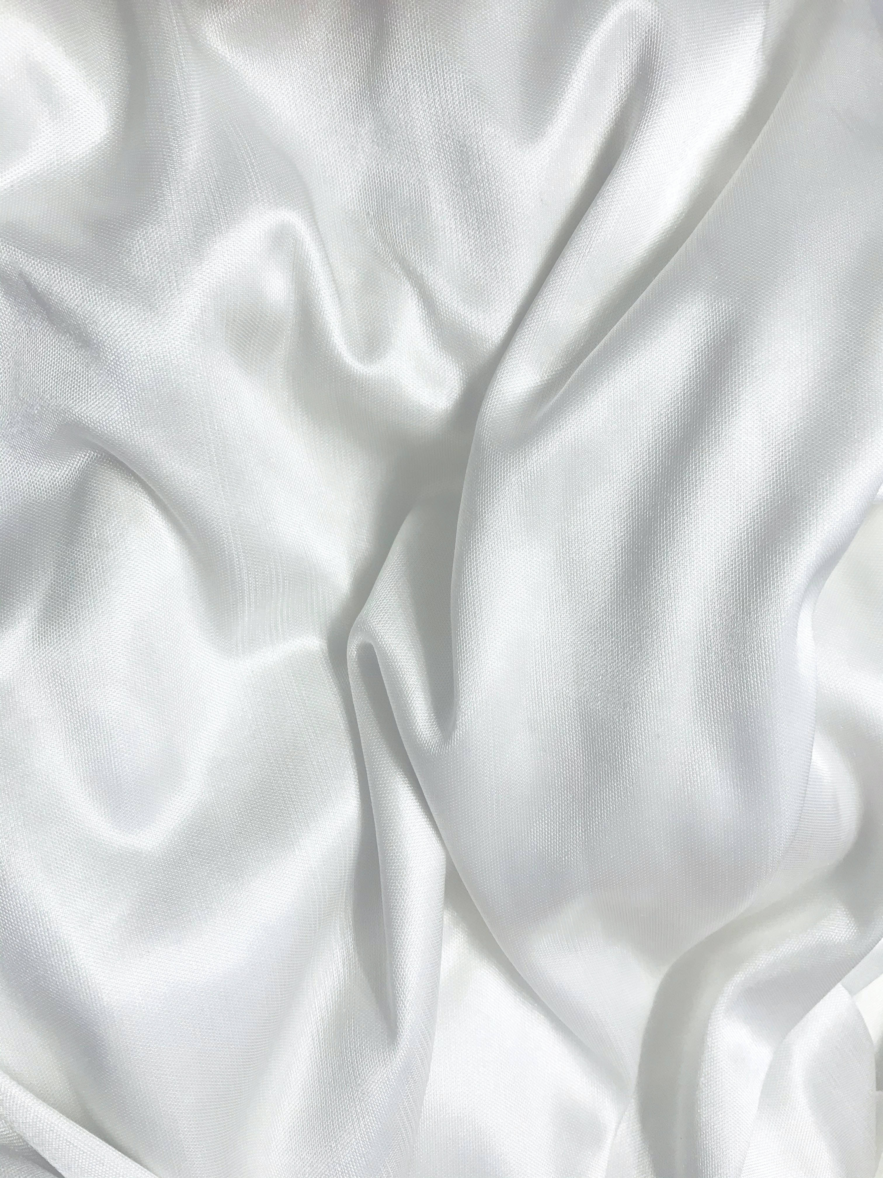 White Pattern 桌布 壁紙 — 豪華白色緞面布料特寫，帶有柔軟皺褶和柔和亮點。