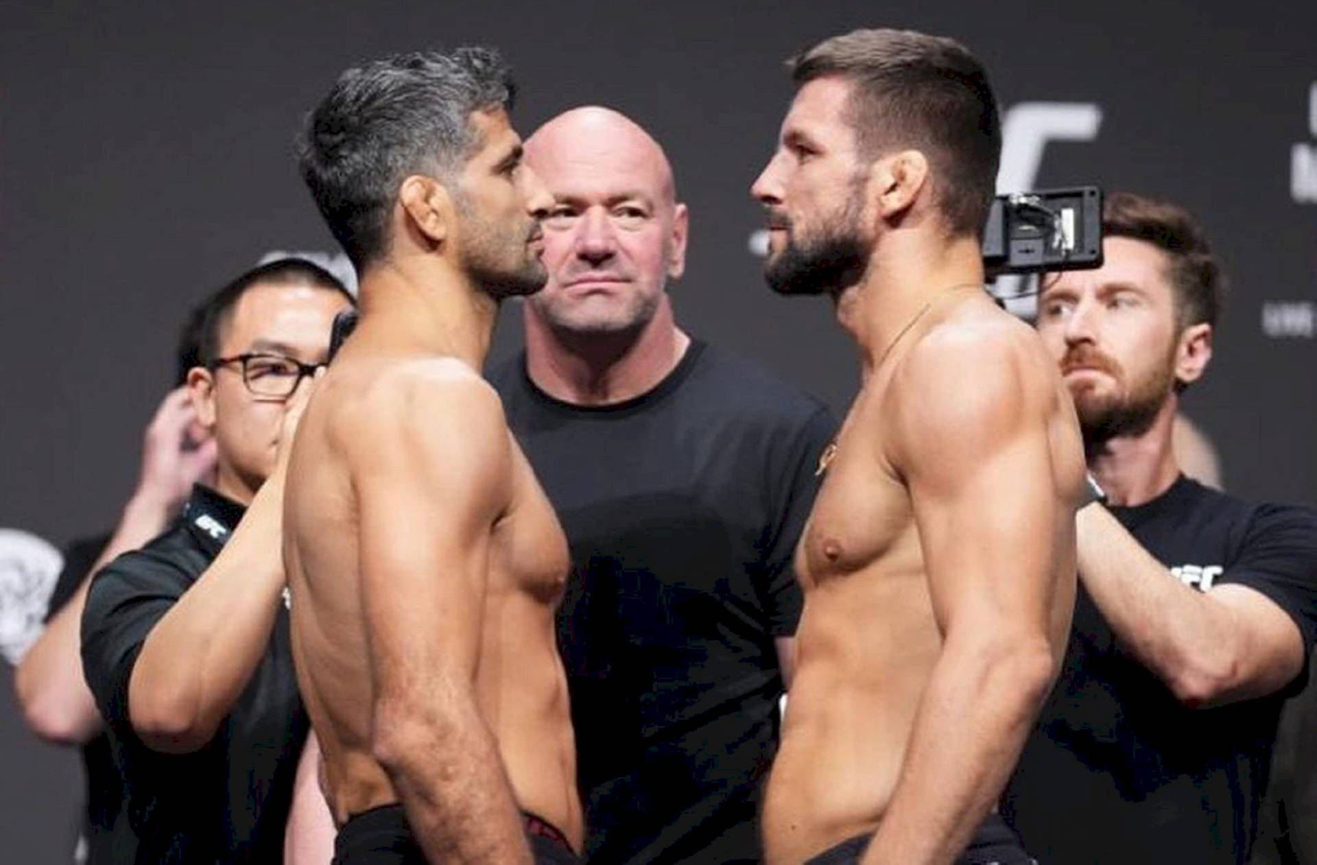 兩名赤膊的MMA拳手在UFC稱重活動中面對面互相凝視。