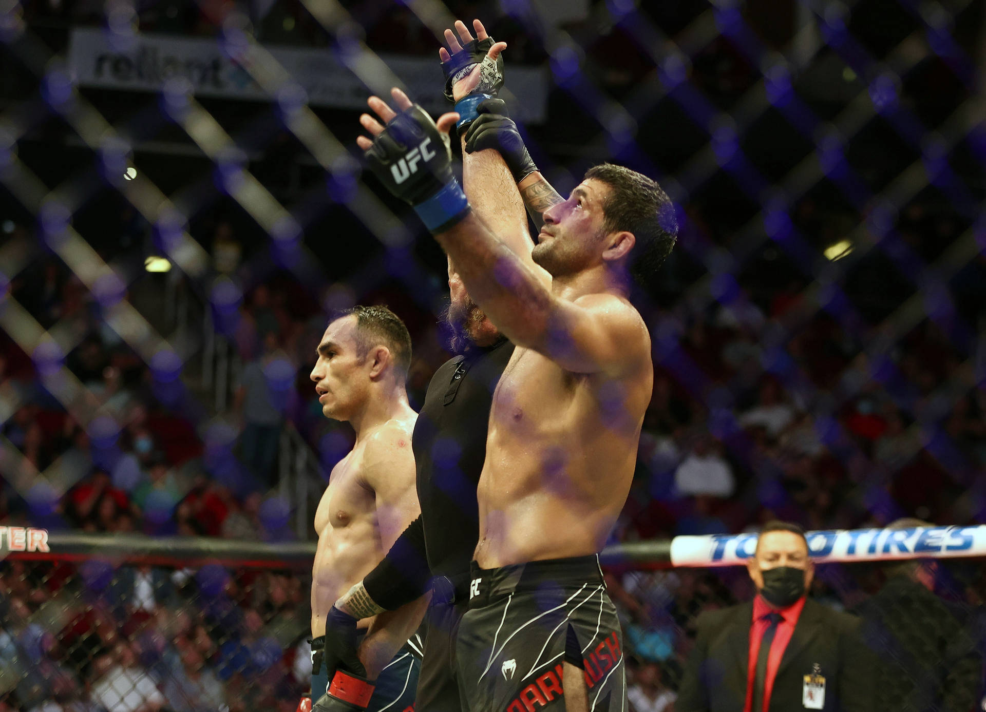 UFC拳手在八角籠內與裁判和對手一起慶祝勝利。