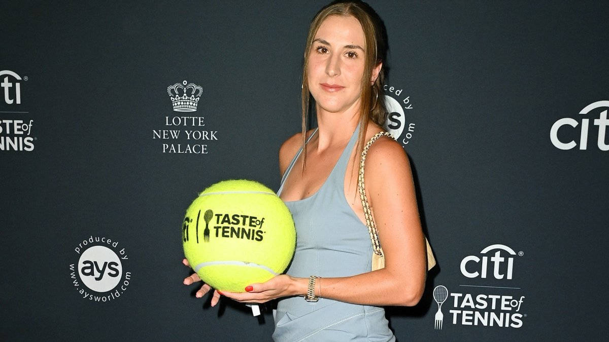 女性在 Taste of Tennis 活動中手持巨大網球。