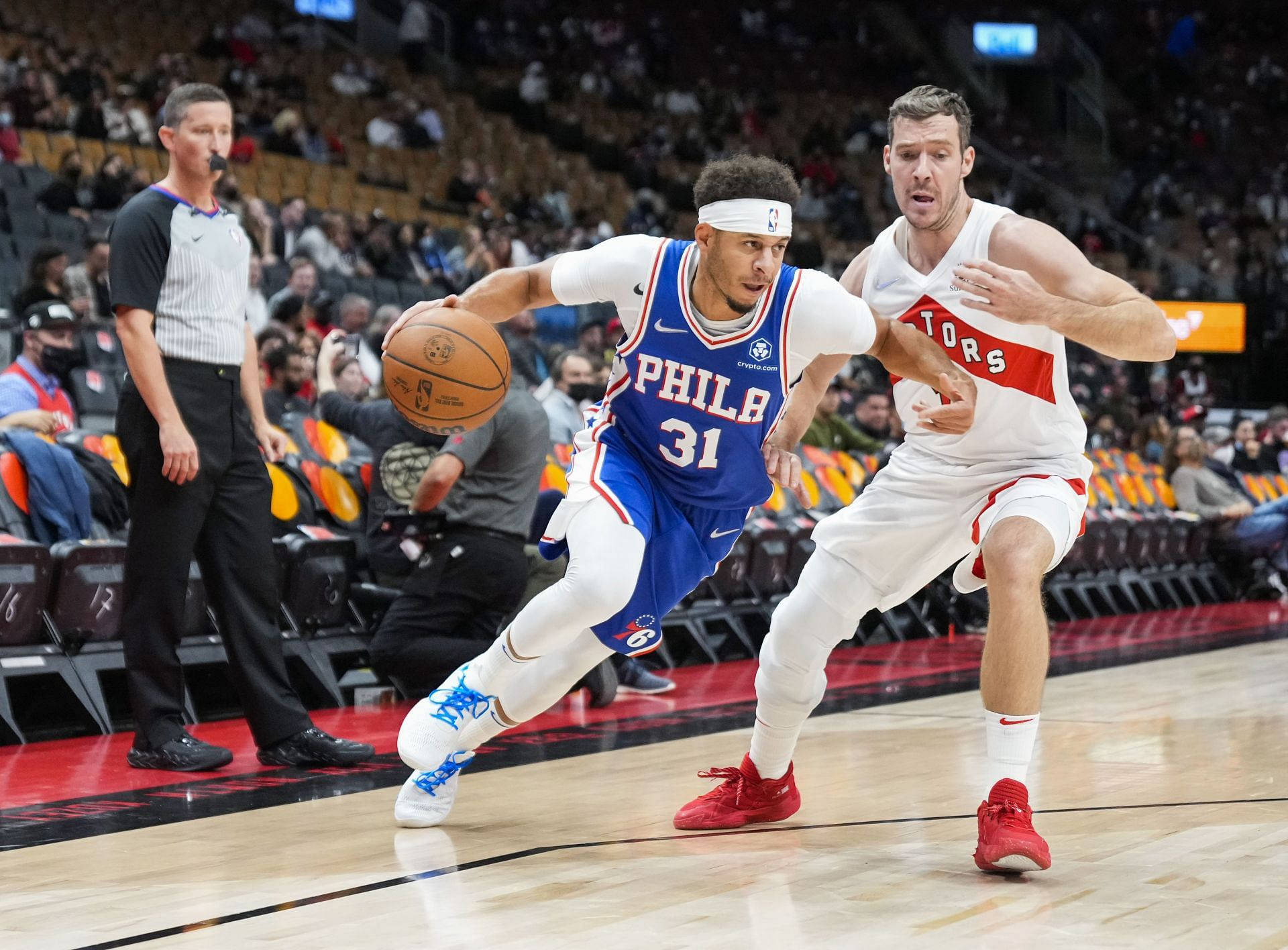 費城76人隊球員在NBA比賽中運球越過多倫多速龍隊防守球員。