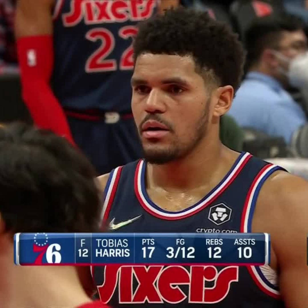 費城76人隊托拜厄斯·哈里斯個人得分站立 壁紙 — Tobias Harris 身穿費城76人球衣，在籃球比賽中專注地看著統計數據疊加。