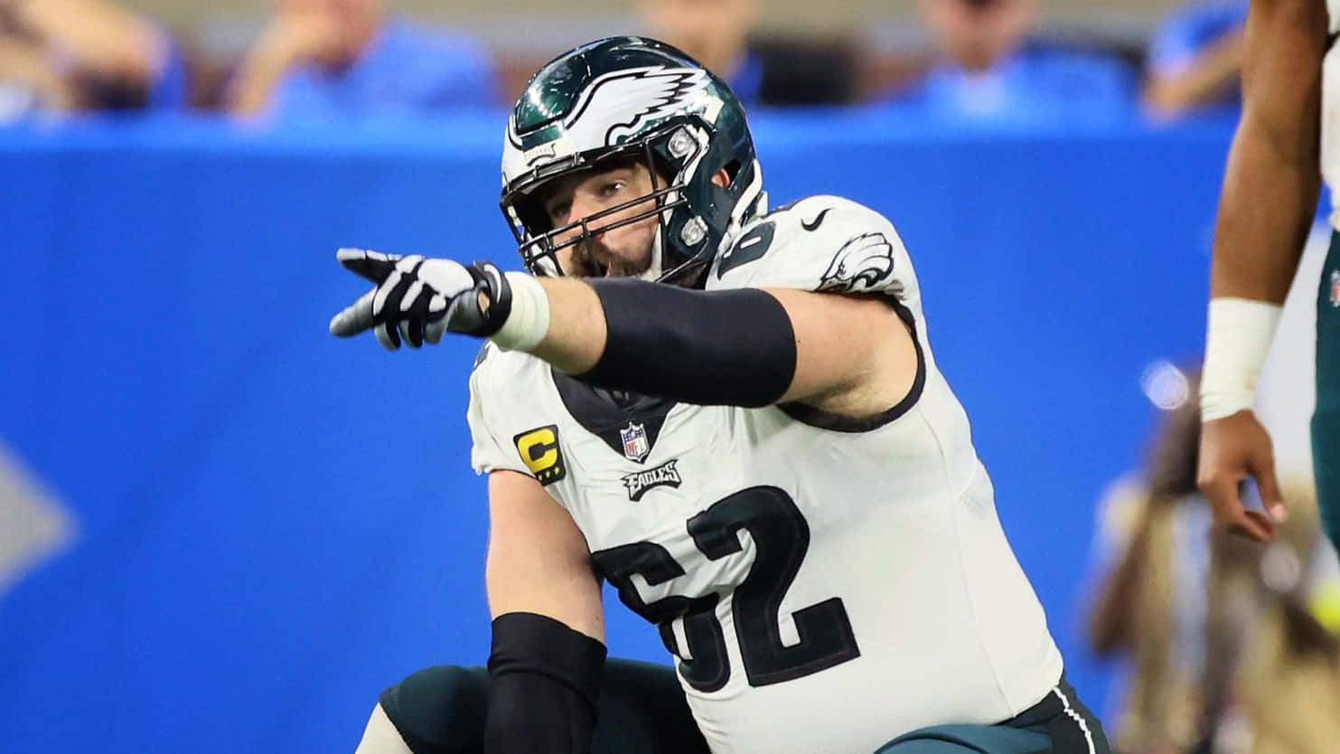 Jason Kelce 桌布 壁紙 — 費城老鷹隊美式足球員52號身穿白色球衣，在球場燈光下比賽中激烈地指著。