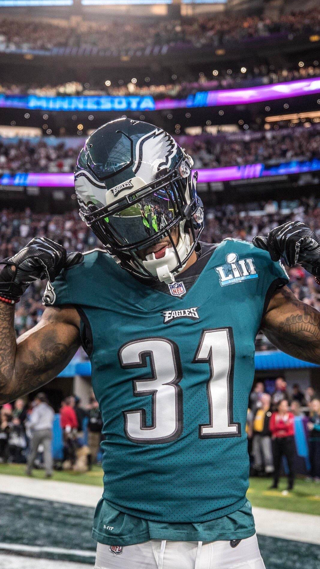 身穿老鷹隊球衣的美式足球員在夜間比賽中慶祝勝利。