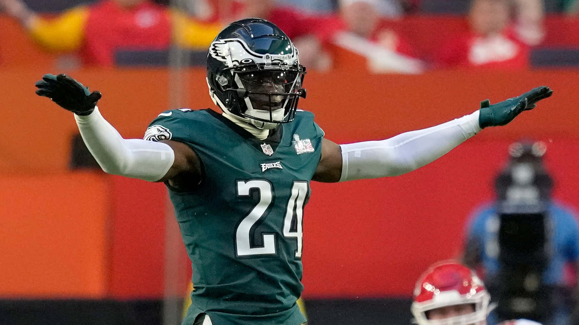 James Bradberry 桌布 壁紙 — 費城老鷹隊足球運動員24號在球場上張開雙臂，穿著綠色球衣慶祝。