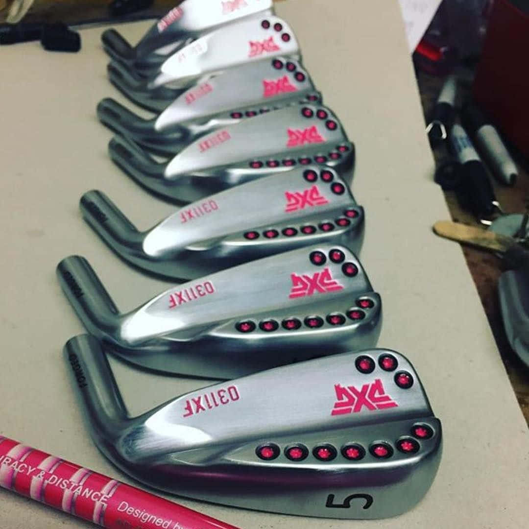 PXG 高爾夫鐵桿帶有紅色點綴，整齊排列在工作台上。