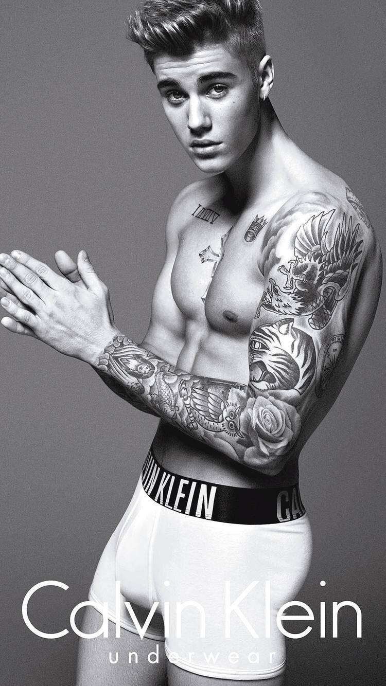 一位有紋身的男子穿著Calvin Klein內衣為時尚照片擺姿勢。