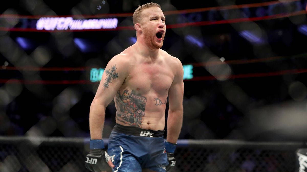 UFC鬥士在八角籠中慶祝勝利，紋身清晰可見。