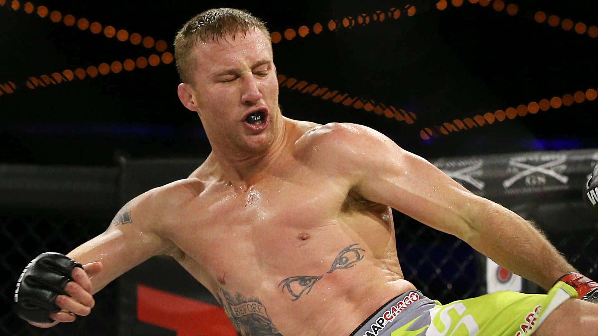 一名男性MMA拳手在八角籠內比賽時因疼痛而扭曲表情。