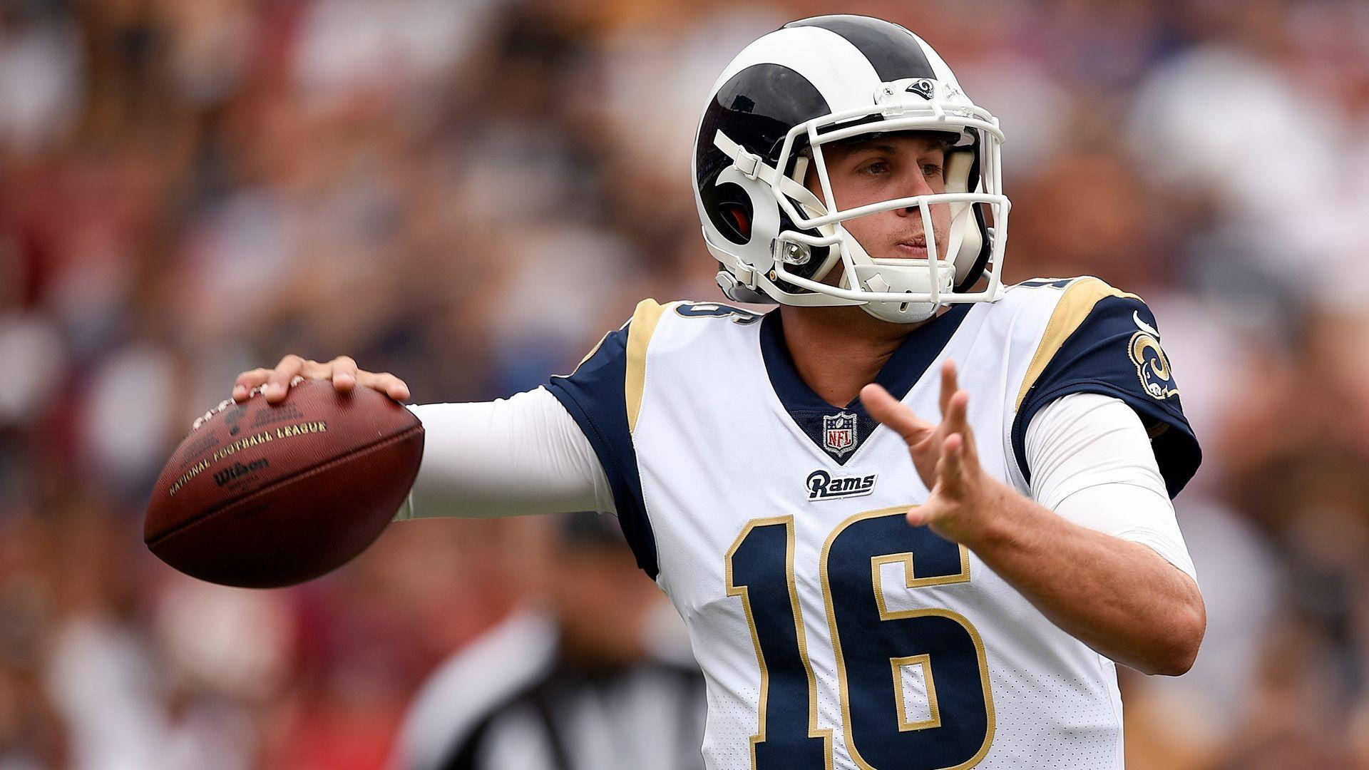 賈瑞德·高夫比賽瞬間 壁紙 — 一位專注的NFL四分衛身穿白色公羊隊16號球衣，在日間比賽中準備擲出橄欖球。