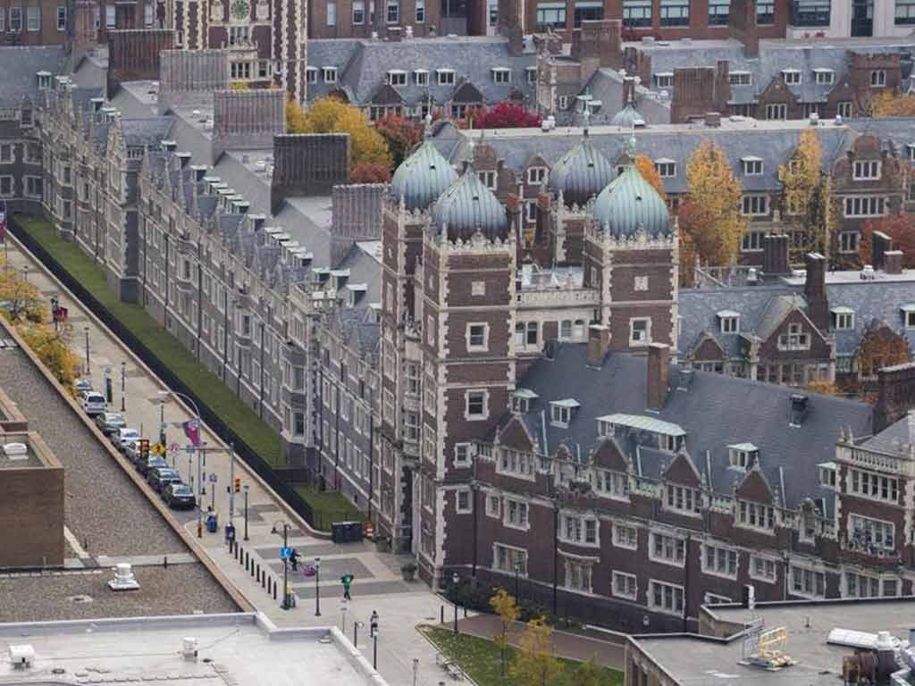 大學建築的鳥瞰圖，帶有秋季樹木和校園街道。