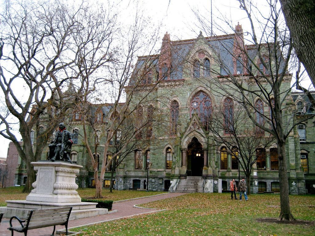 秋季校園中的哥德式大學建築，光禿的樹木和雕像。