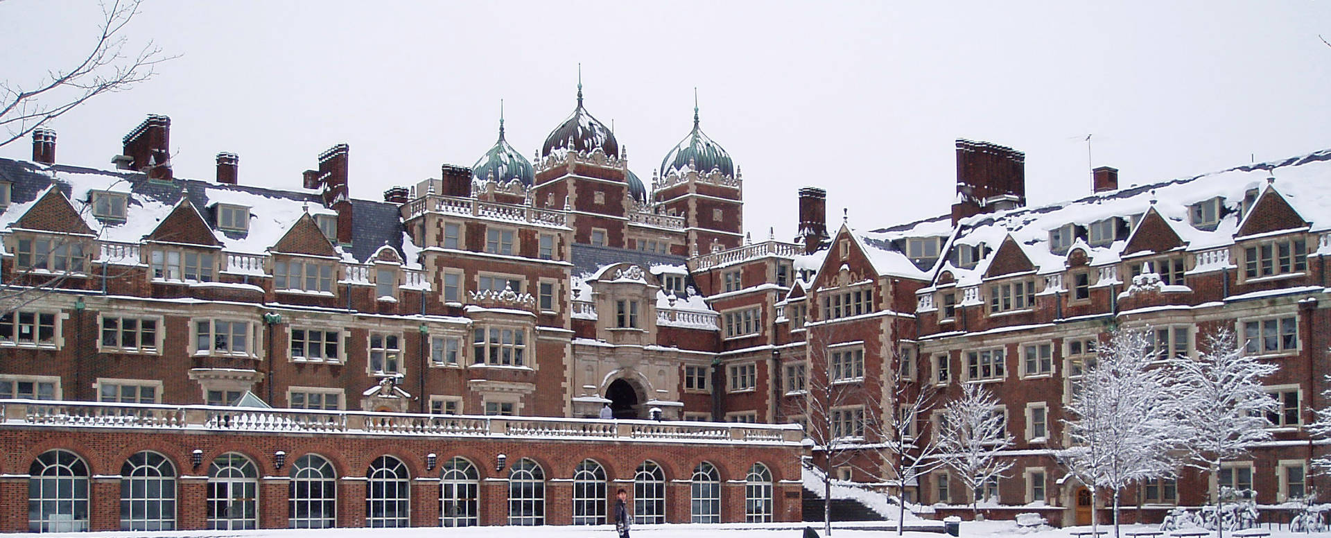 積雪的歷史大學建築，帶有圓頂塔樓和光禿的樹木。