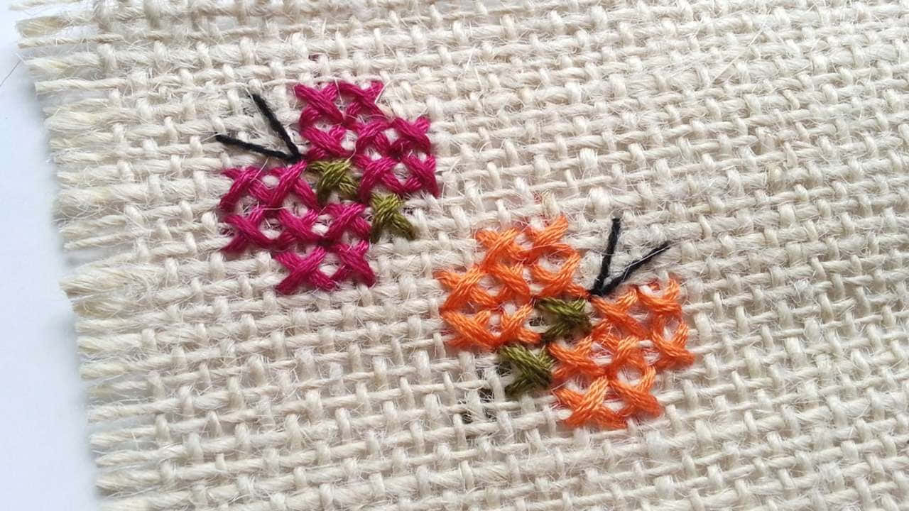 手繡粉紅與橙色花朵在編織布料上，搭配綠葉與黑色花莖。 — 唯美蝴蝶動圖 壁紙