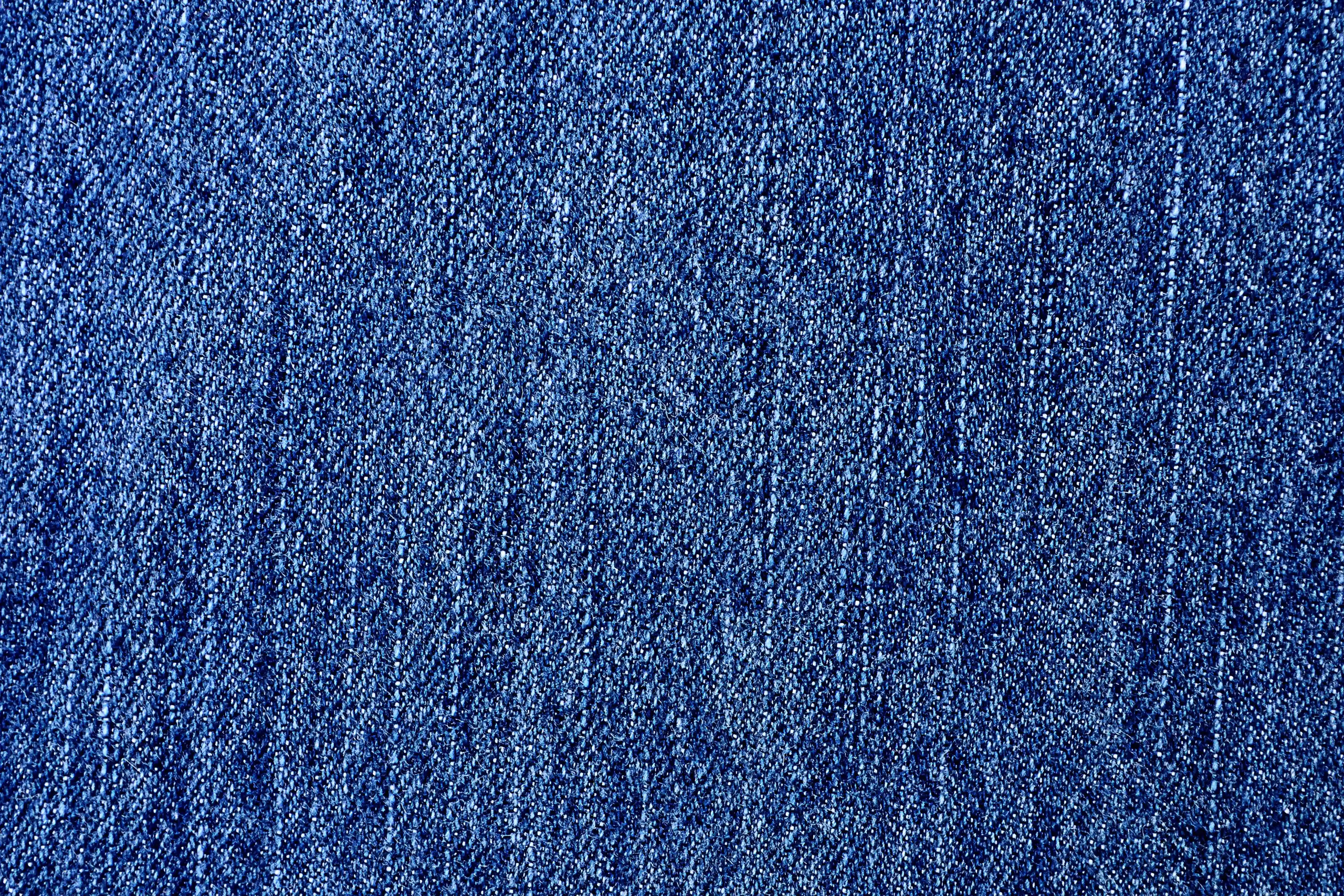 Denim 桌布 壁紙 — 質感藍色牛仔布料的特寫，顯示細緻的編織紋理和微妙的褪色圖案。