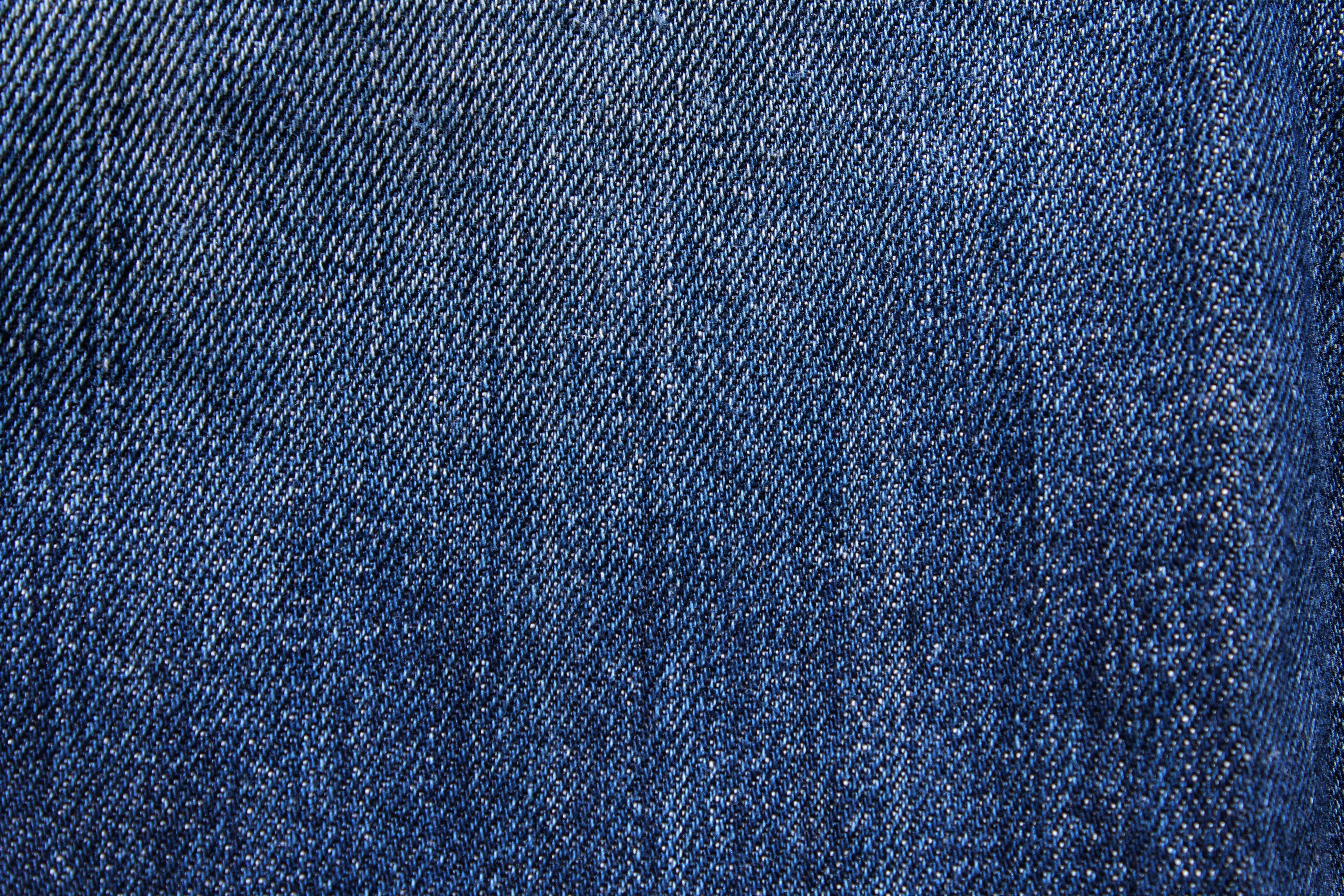 Denim 桌布 壁紙 — 質感藍色牛仔布料的特寫，顯示詳細的編織和微妙的褪色圖案。